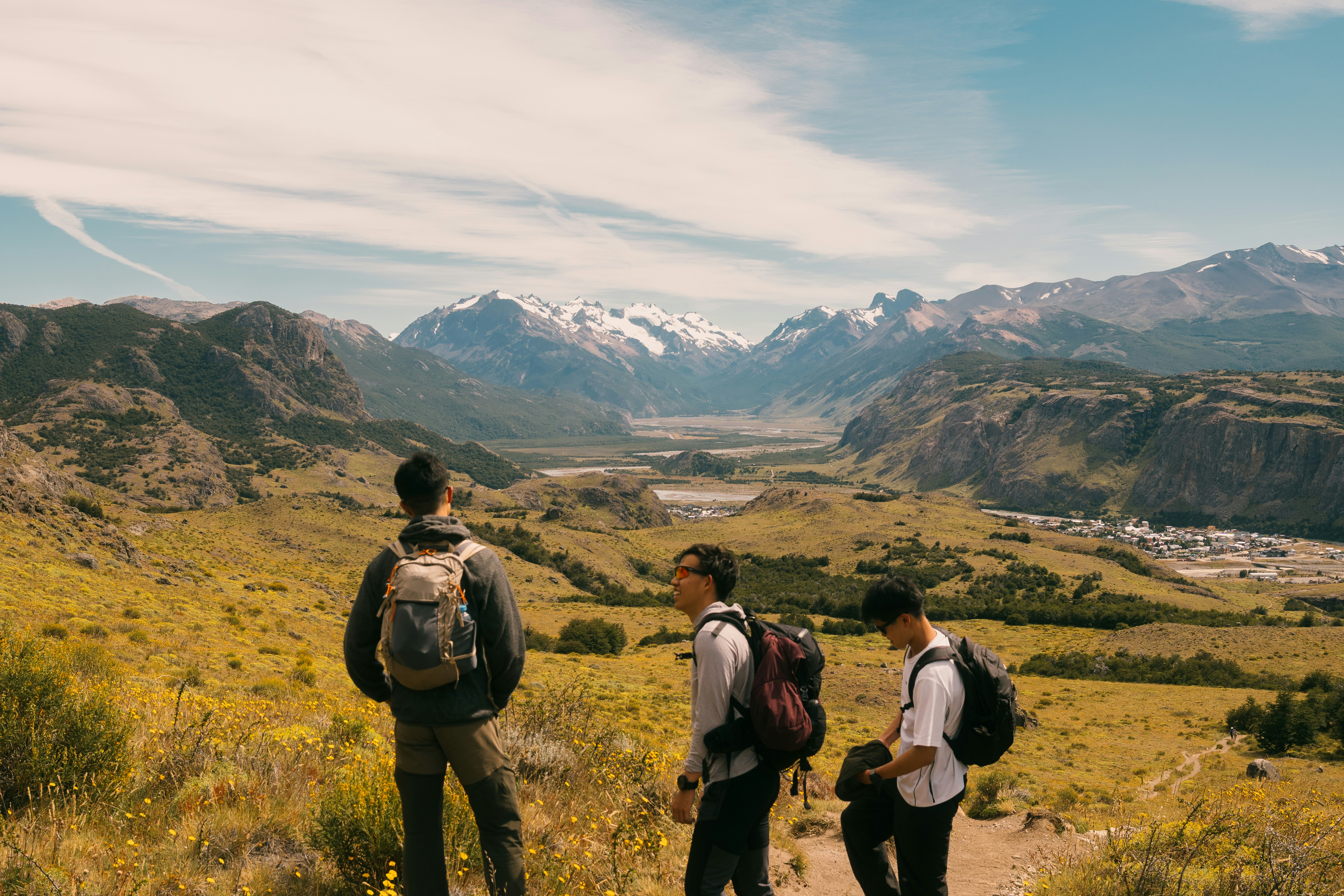 Three hikers observe a vast mountain valley landscape. 풍경 사진