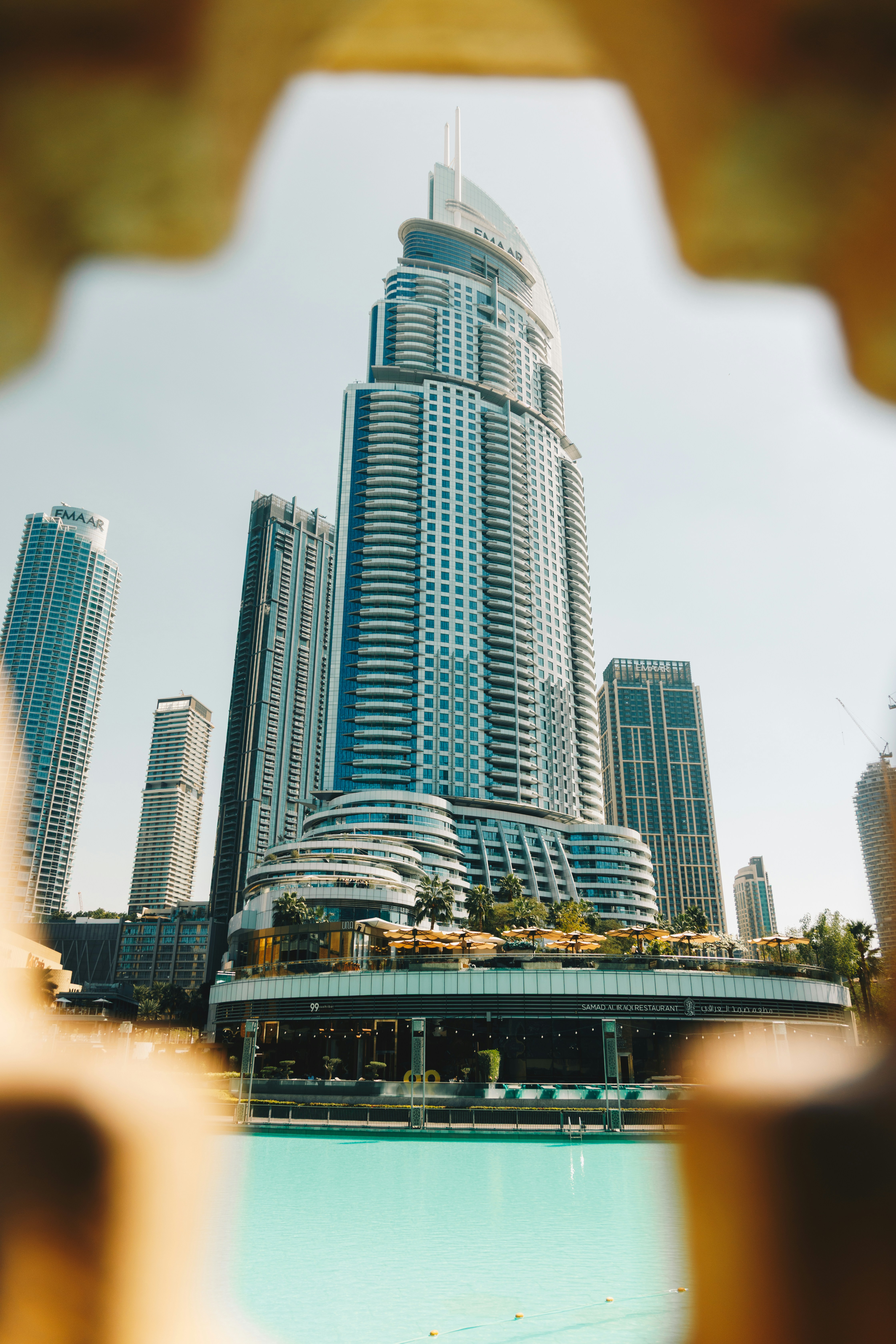 Modern skyscrapers and a turquoise pool on a sunny day.