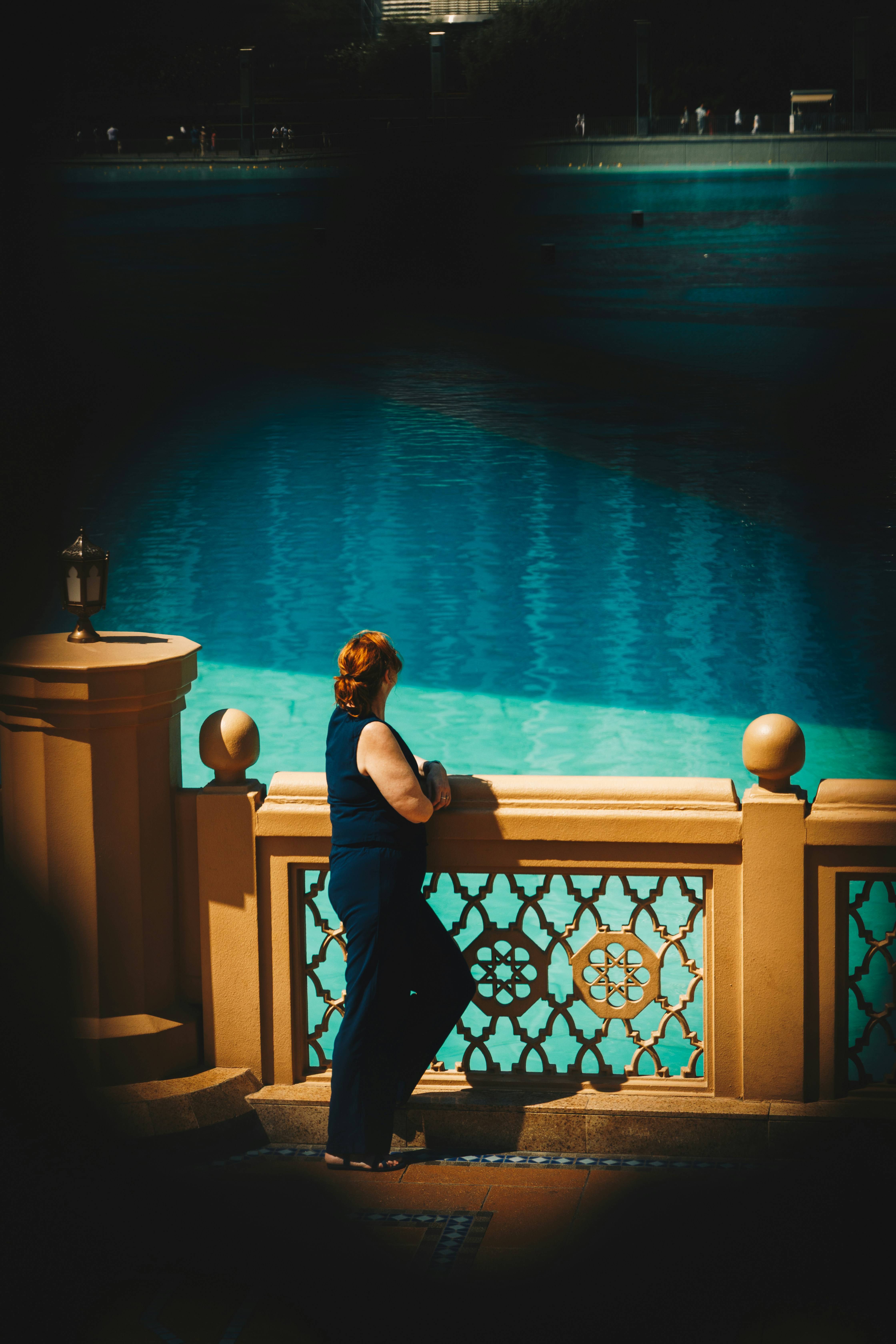 Woman looking out at a bright blue body of water.