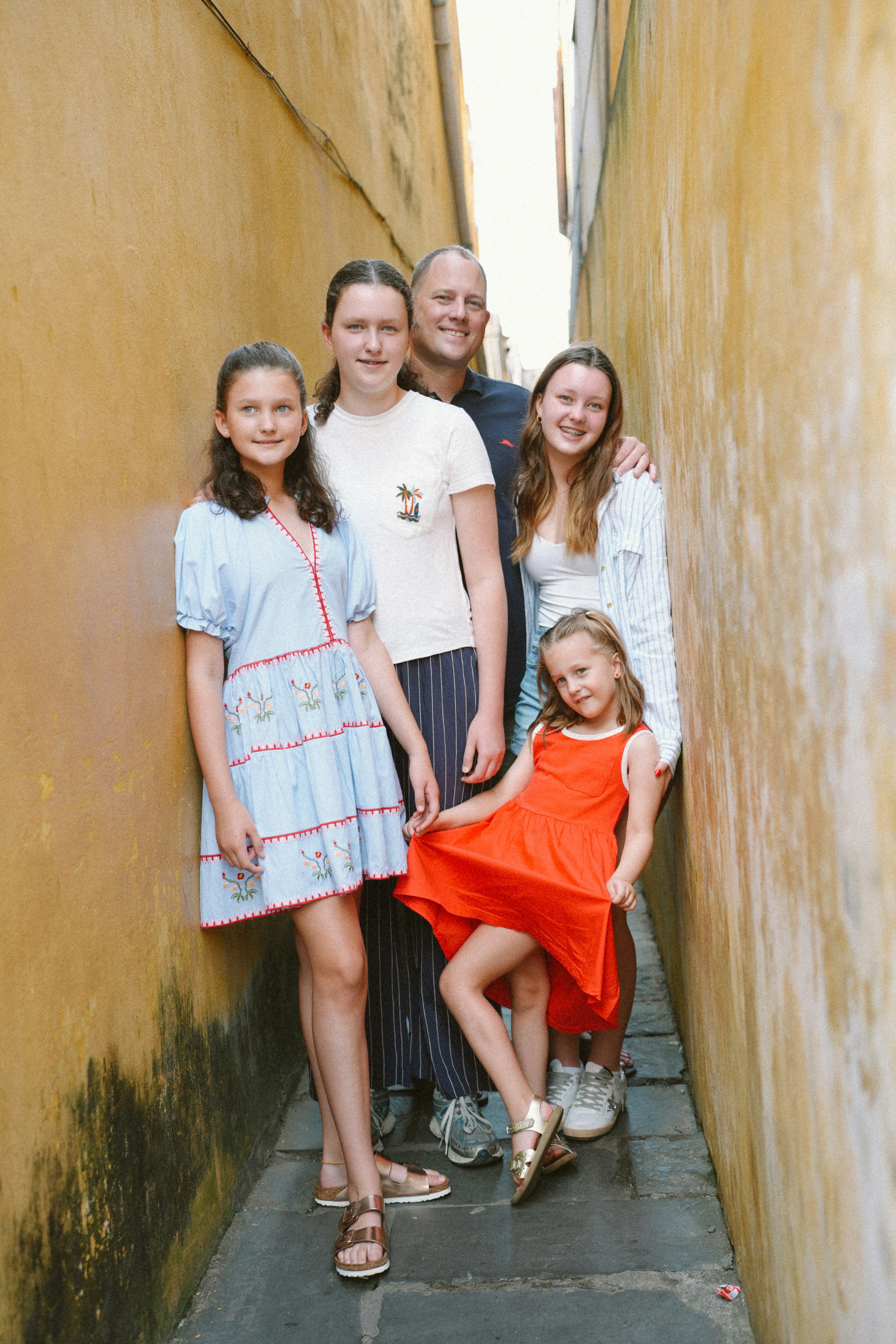 Family standing in front of their new home, smiling and holding keys