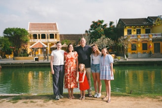 A family poses for a photo by a river.