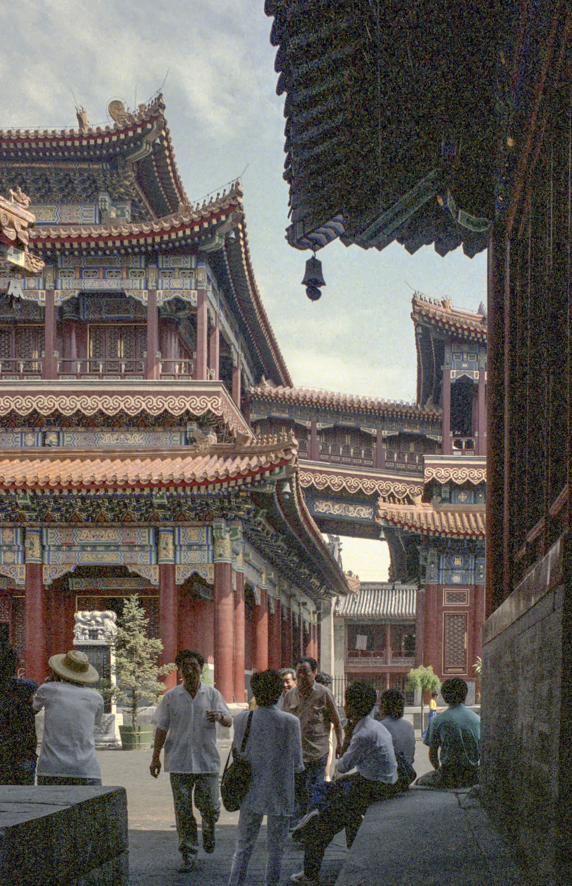 People gather at a traditional temple complex with ornate architecture.