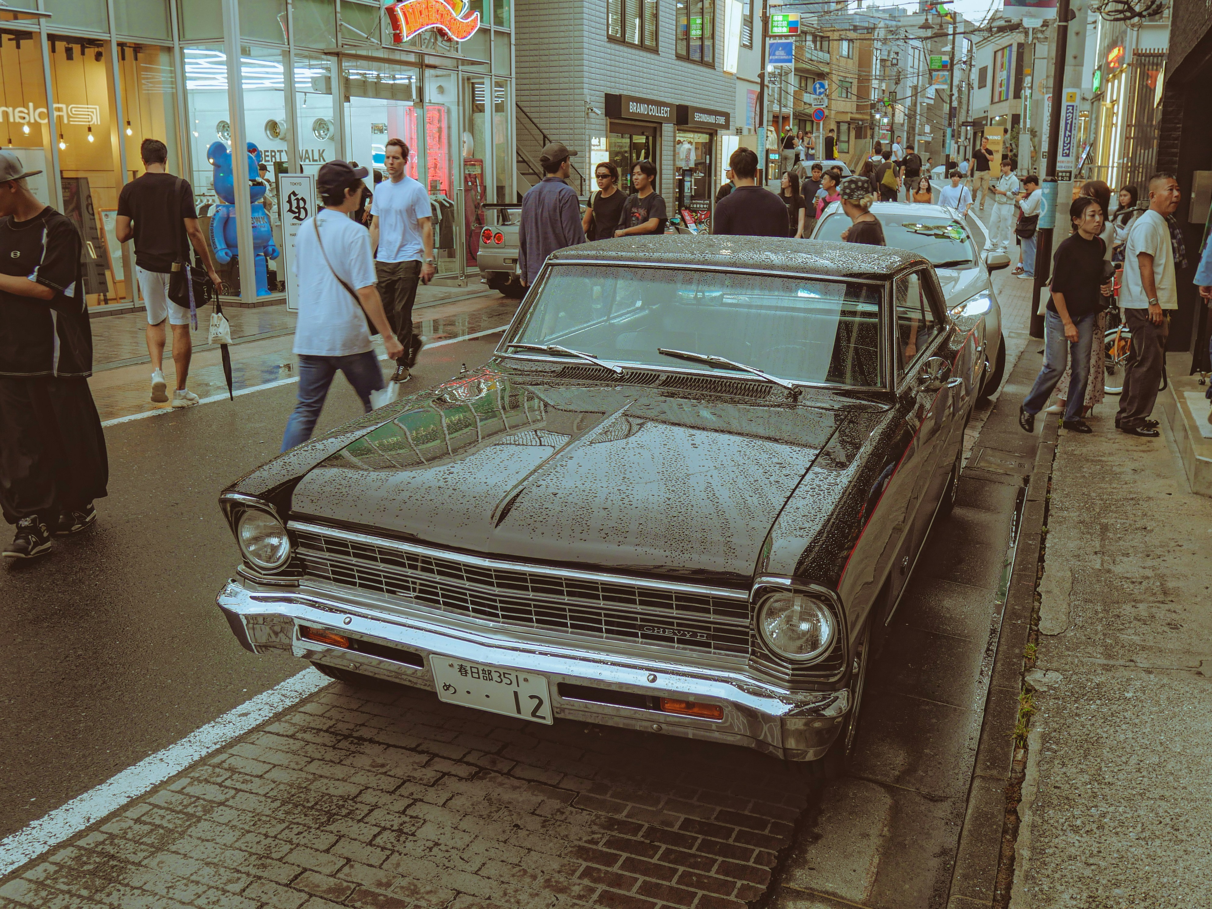 Une voiture noire vintage garée dans une rue de la ville.