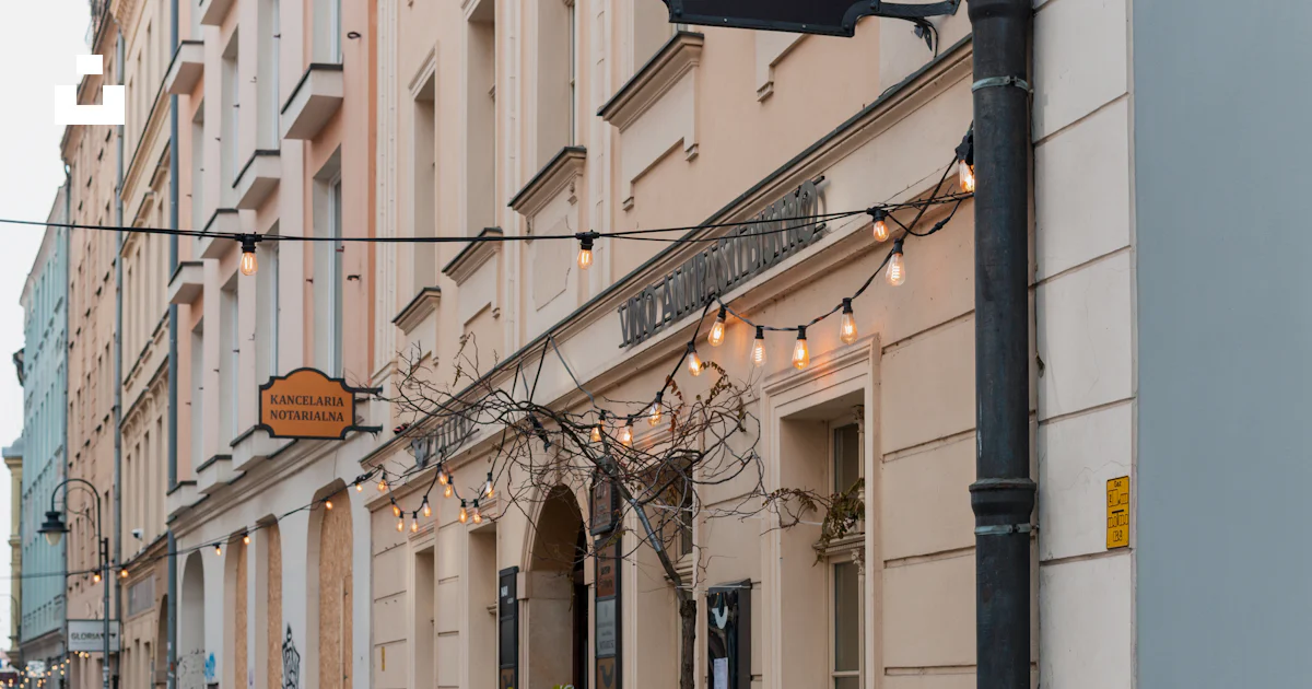 Building With String Building facade with string lights and arched entrance. photo – Free ...