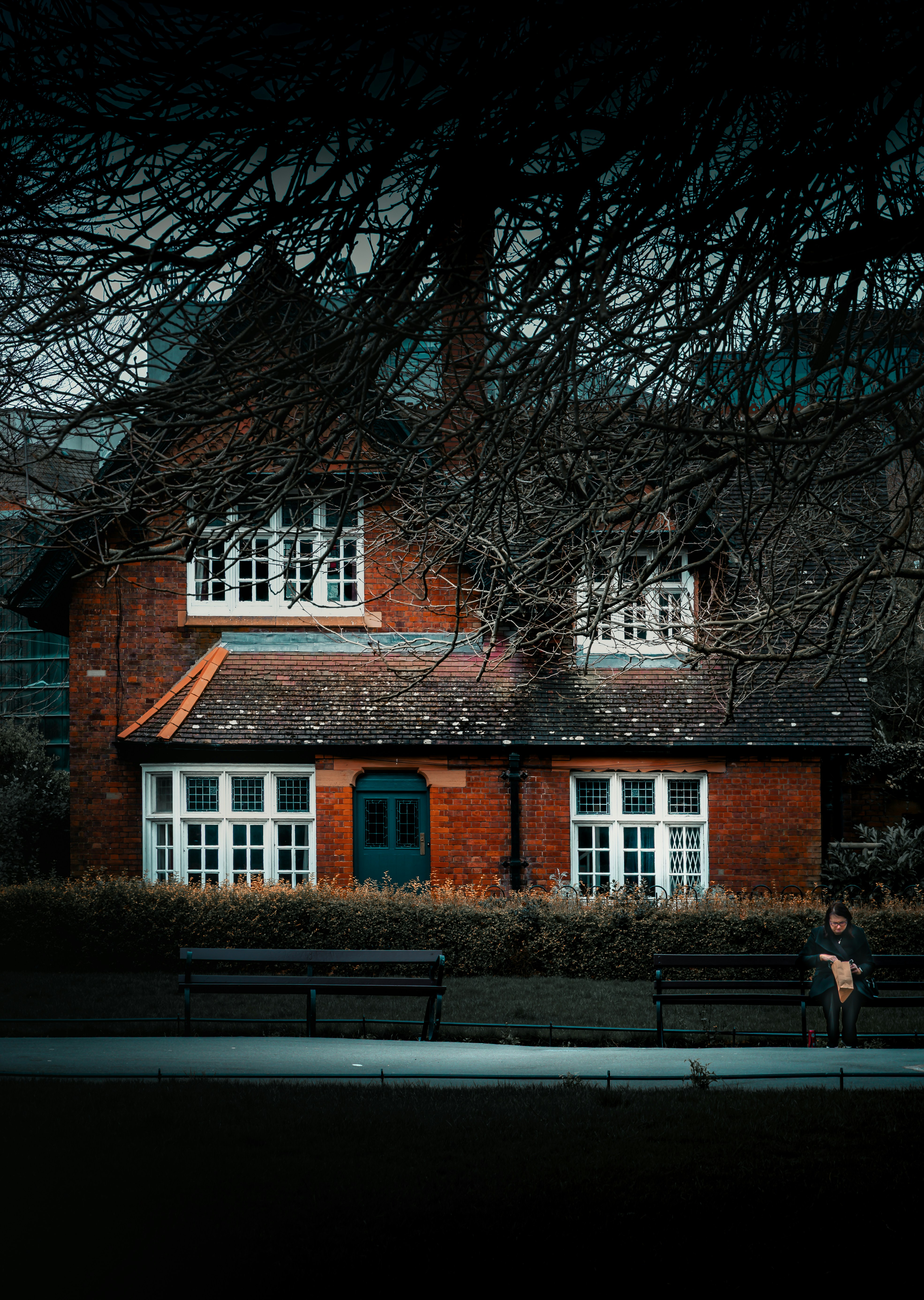 A brick house with large windows and a blue door.