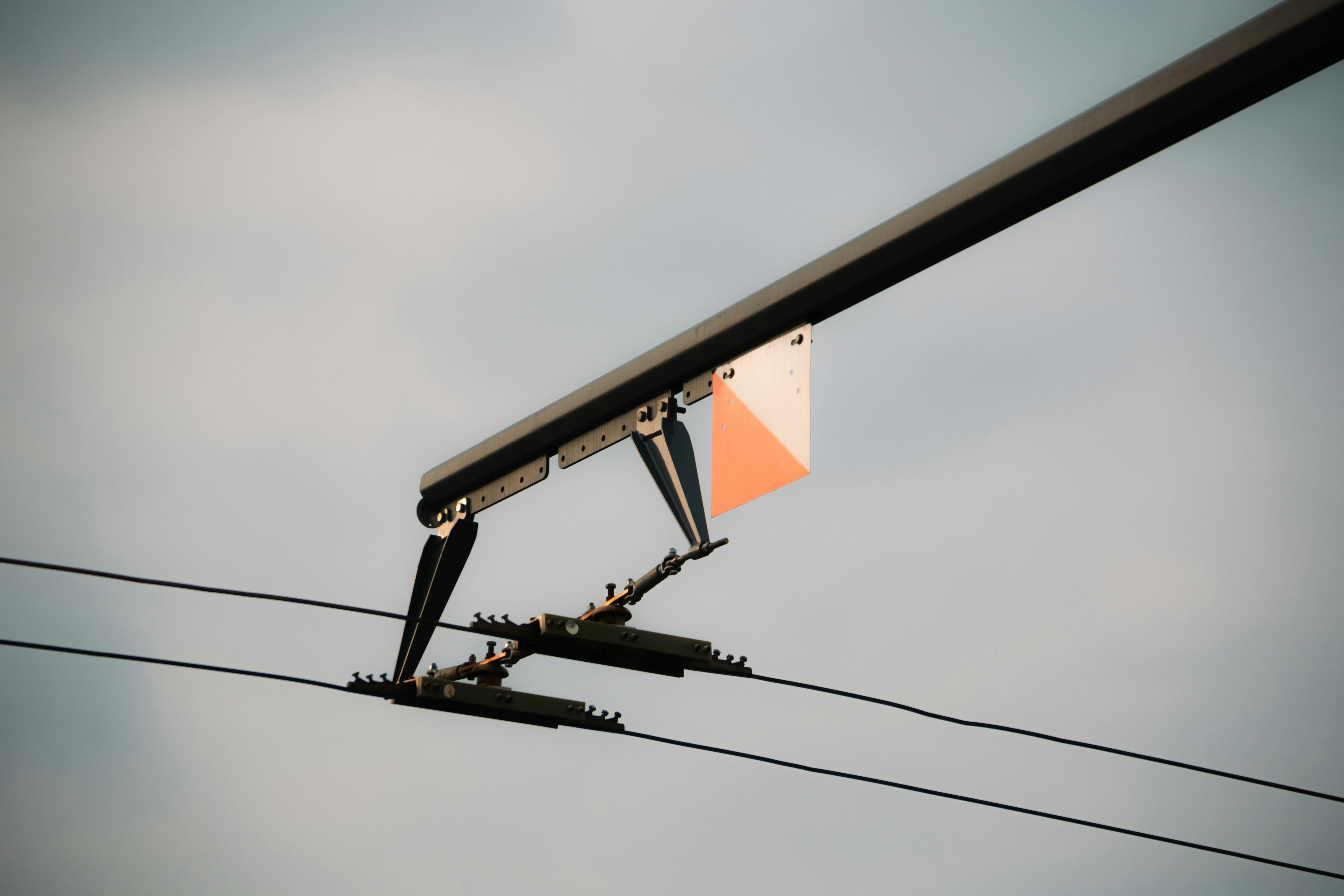 Um marcador laranja e branco preso aos fios aéreos.