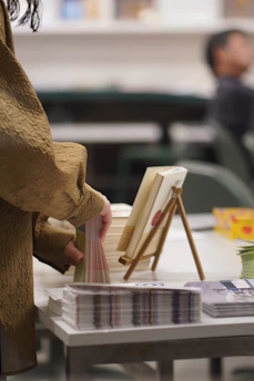 Person arranging books on a table