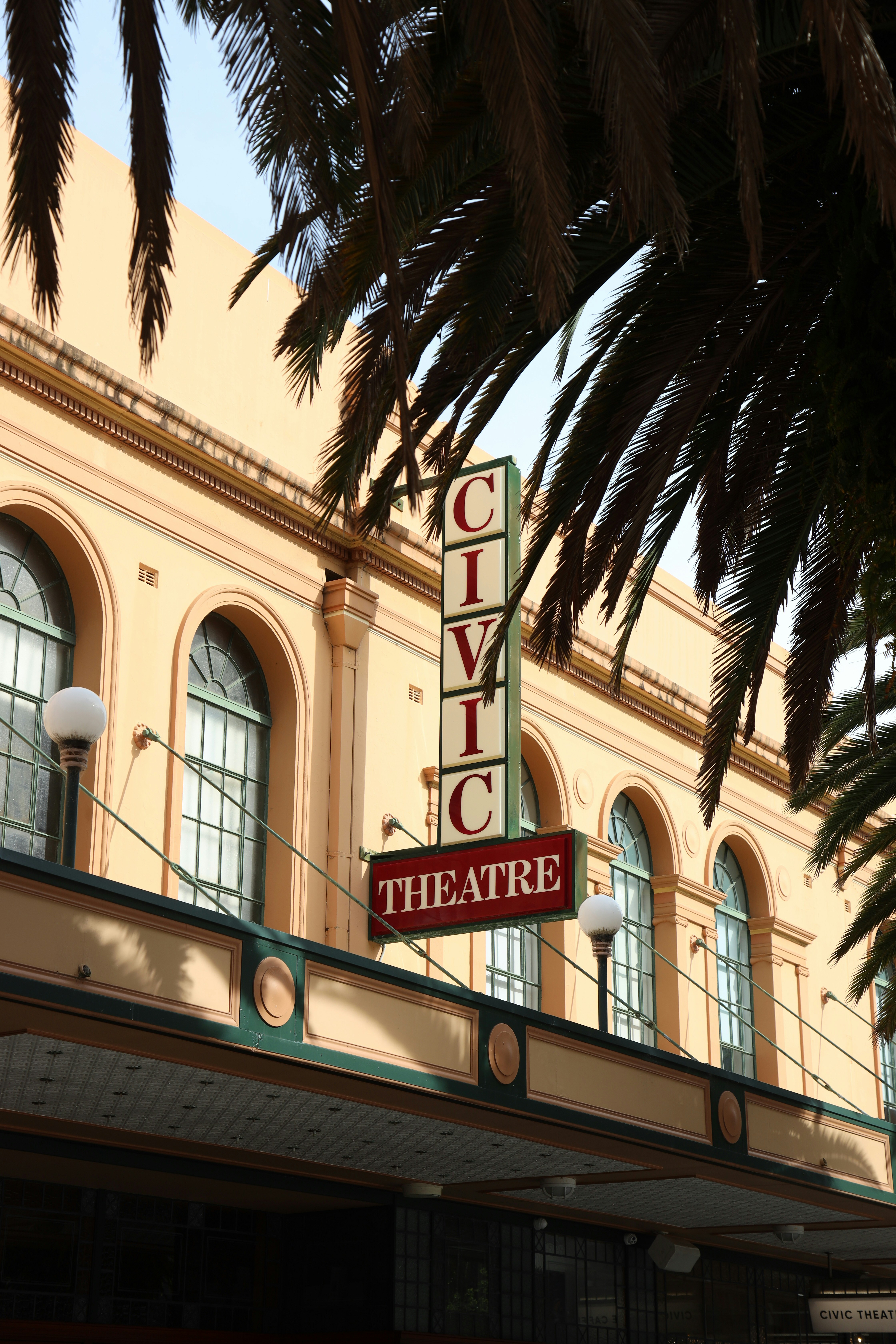Civic theatre building facade with palm trees