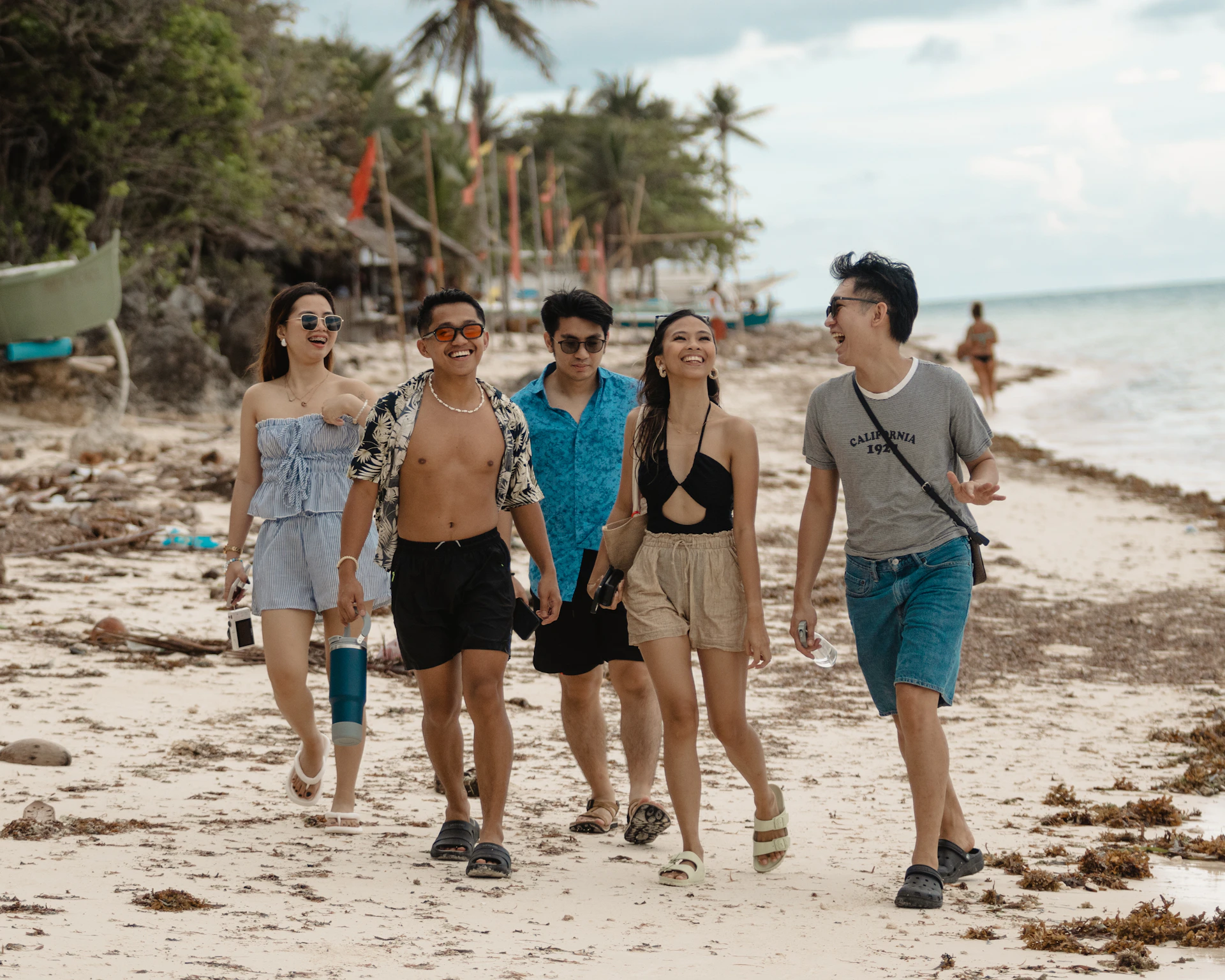A group of friends walking on a tropical beach