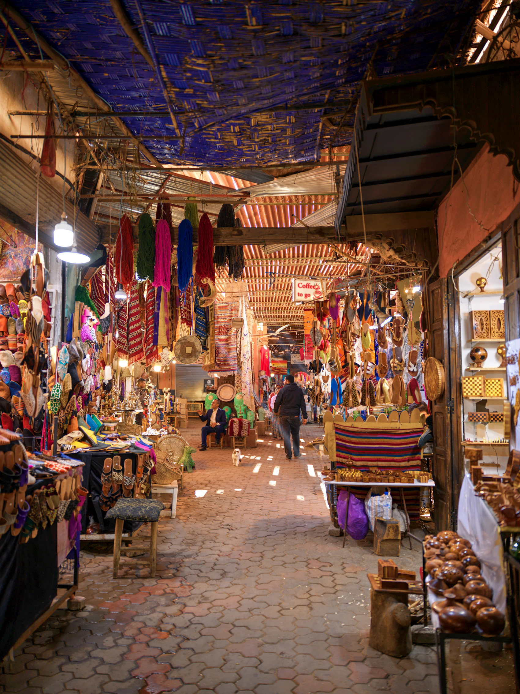 Colourful textiles, lanterns and crafts lining a Marrakesh medina street