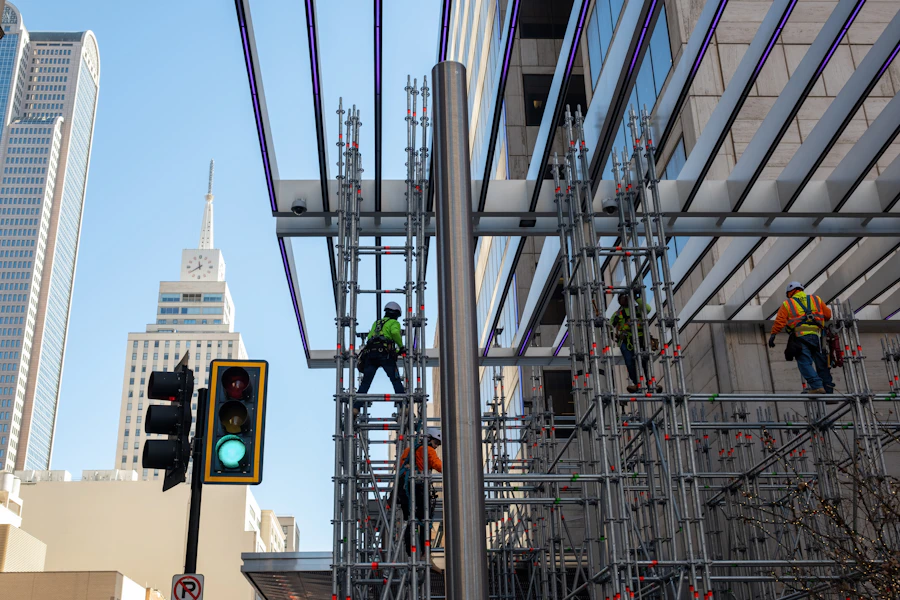 Construction workers on scaffolding near a commercial building