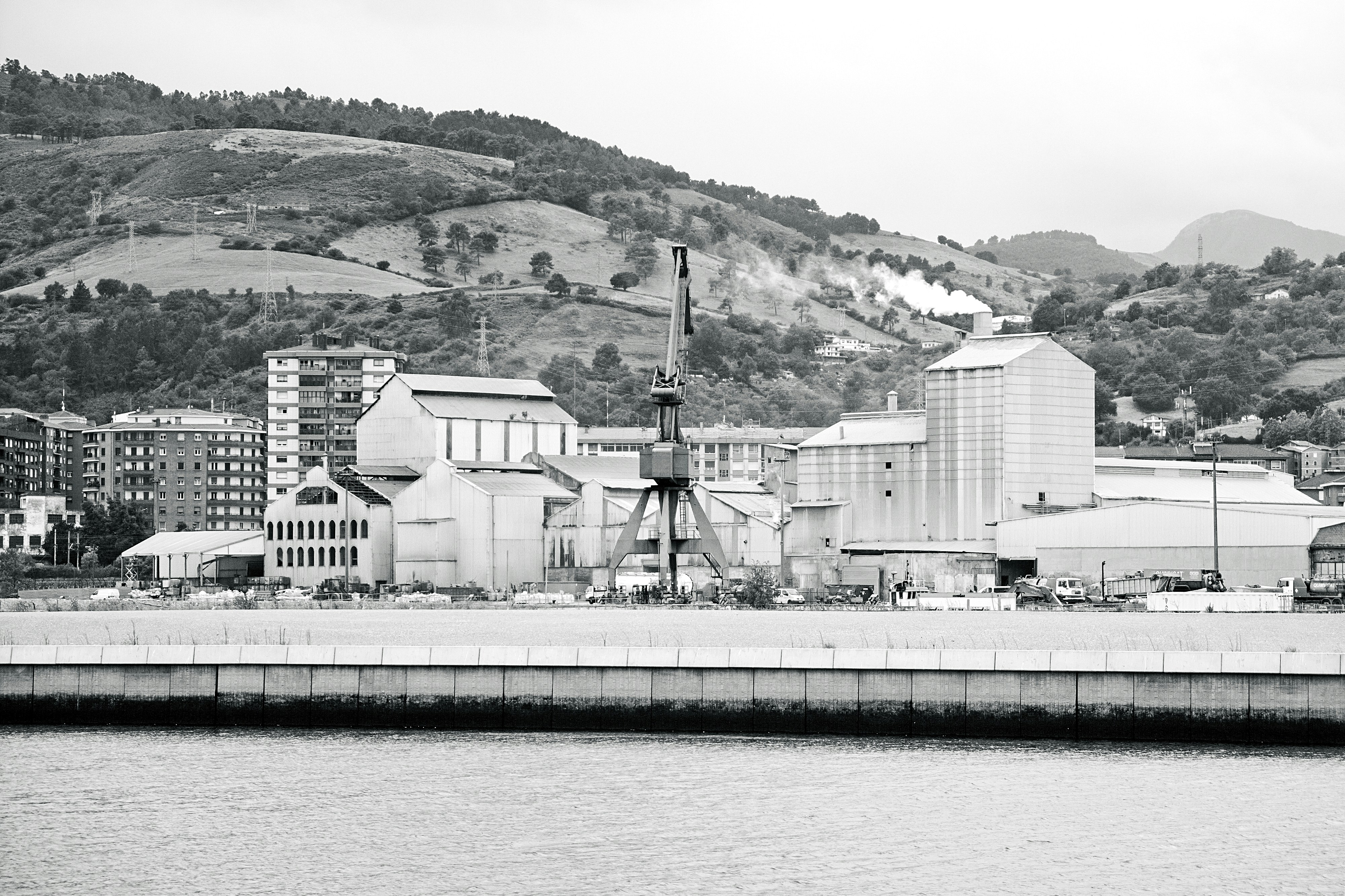Industrial buildings and hills by the water
