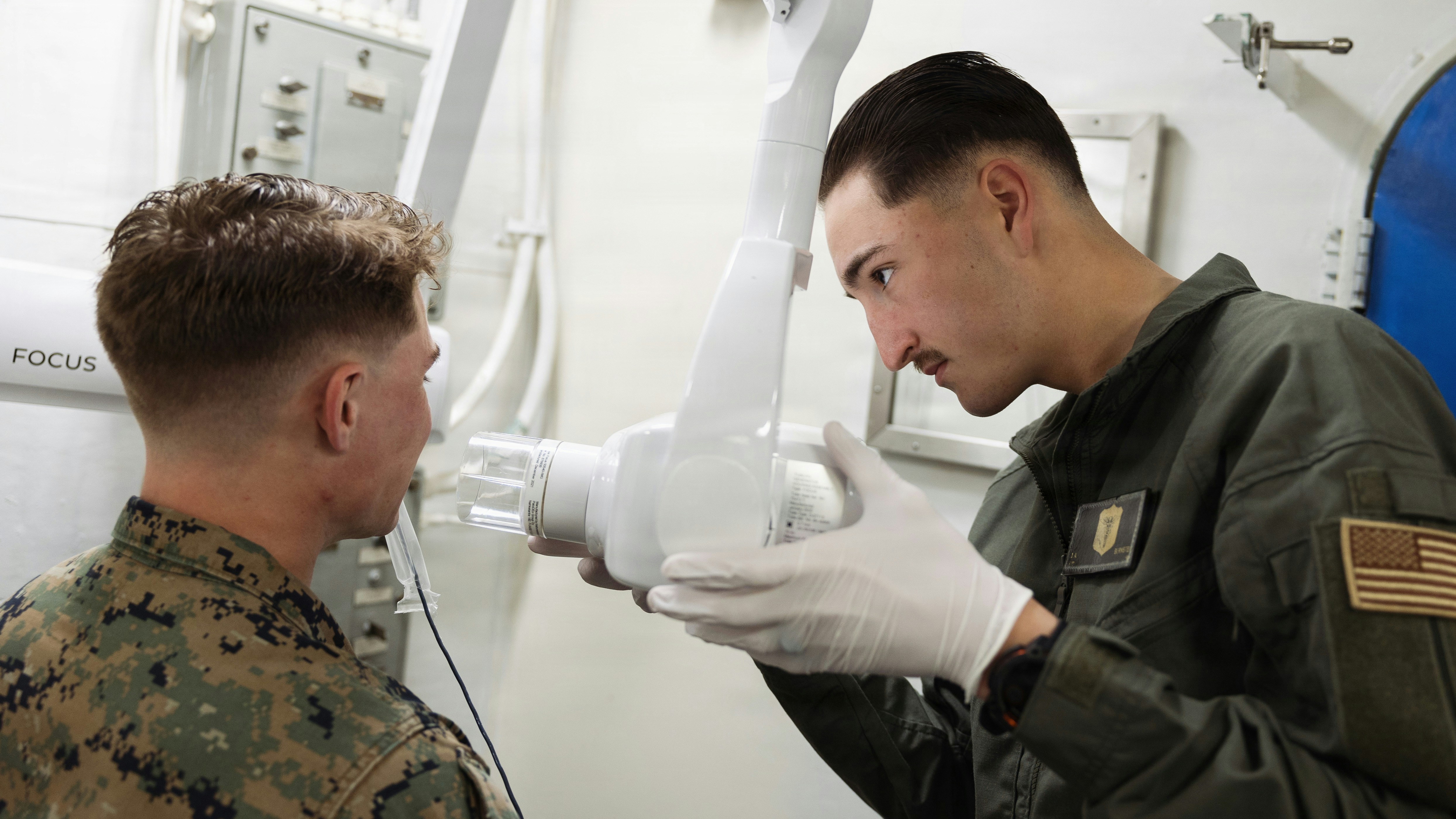 Dentist using dental x-ray machine on patient