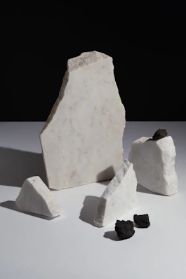 Arrangement of white stones with dark volcanic rock pieces.