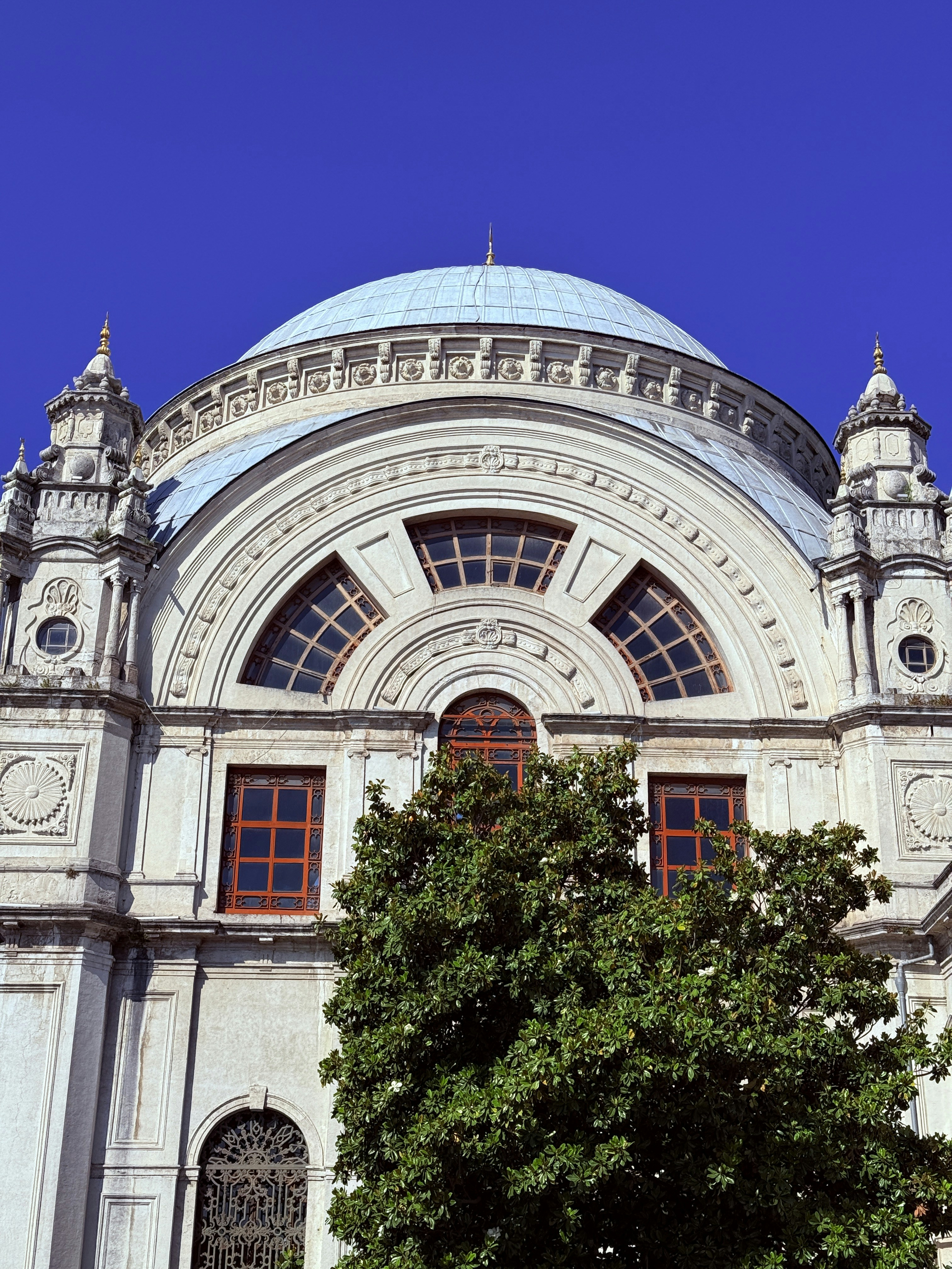 Ornate building facade with a large dome and windows.