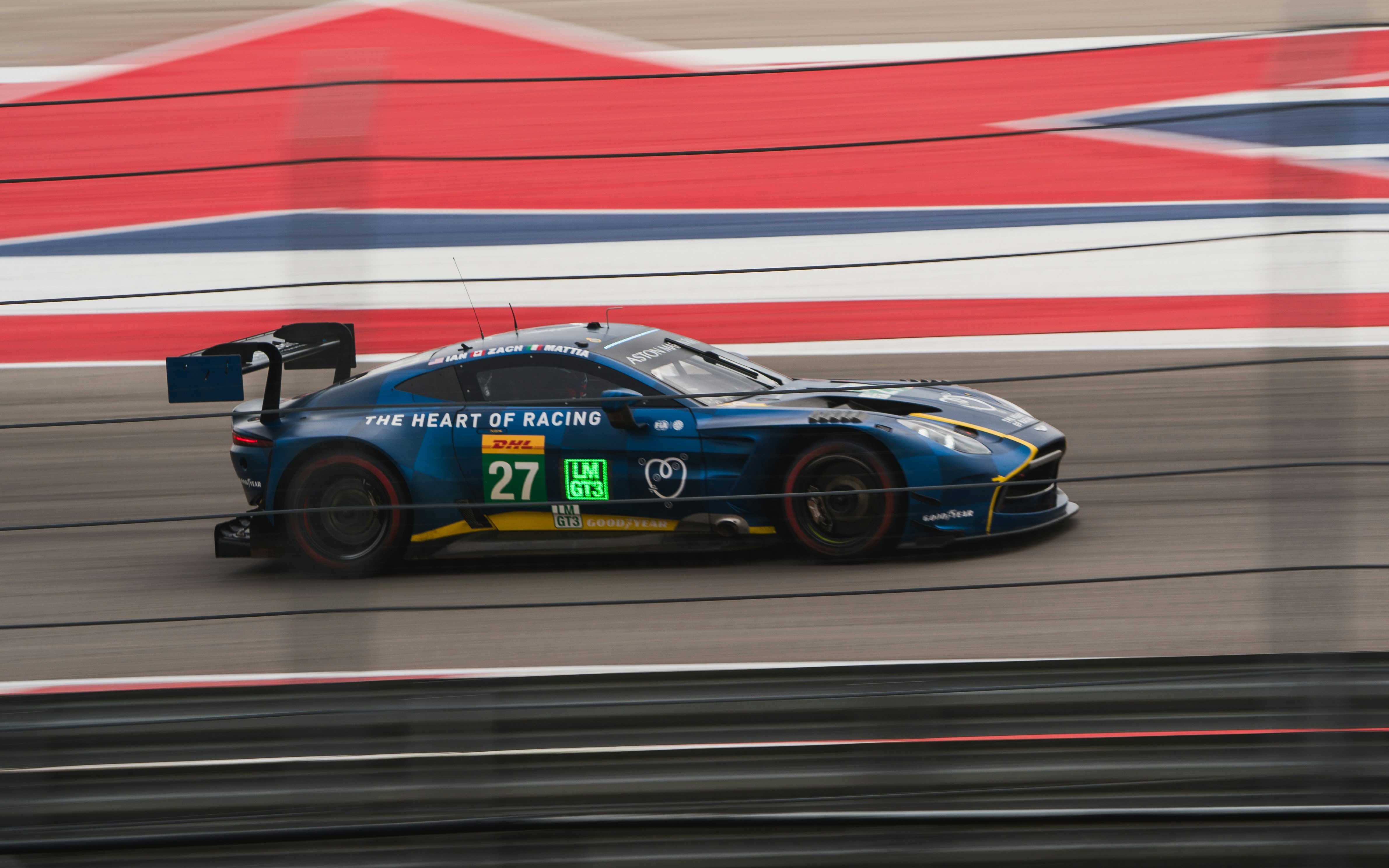 A blue race car speeds down a track.