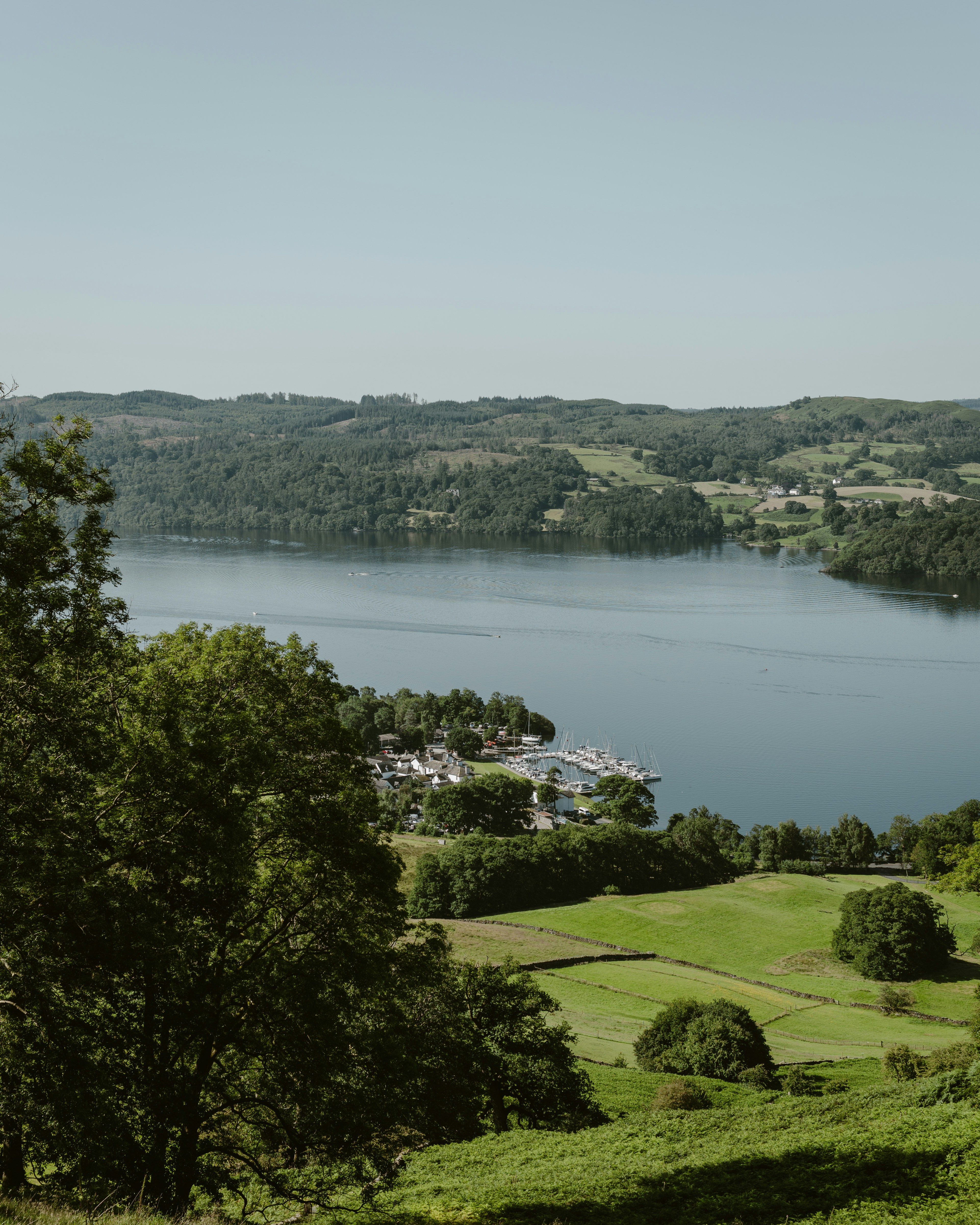 A serene lake surrounded by lush green hills and trees.