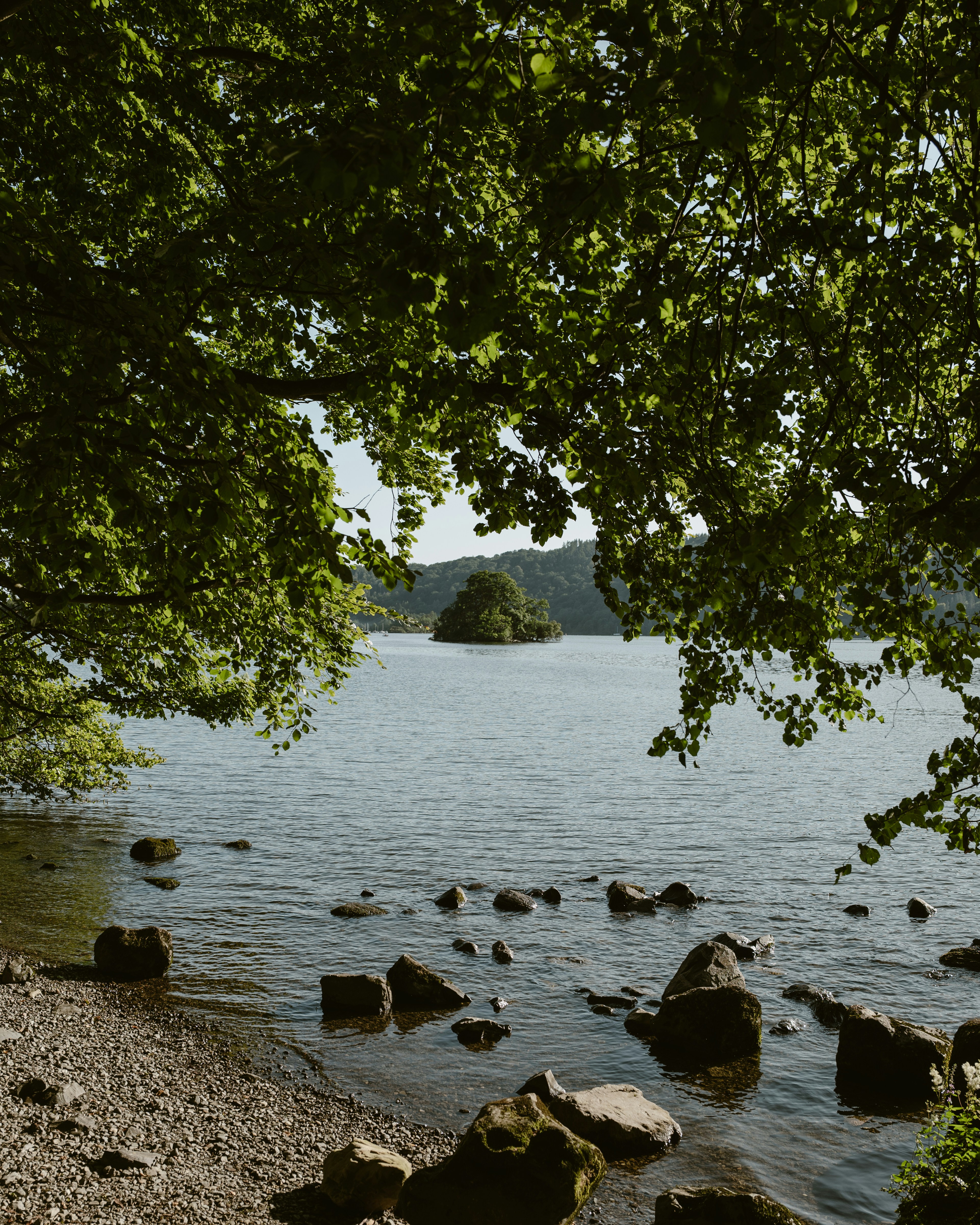 Calm lake with rocky shore and distant island