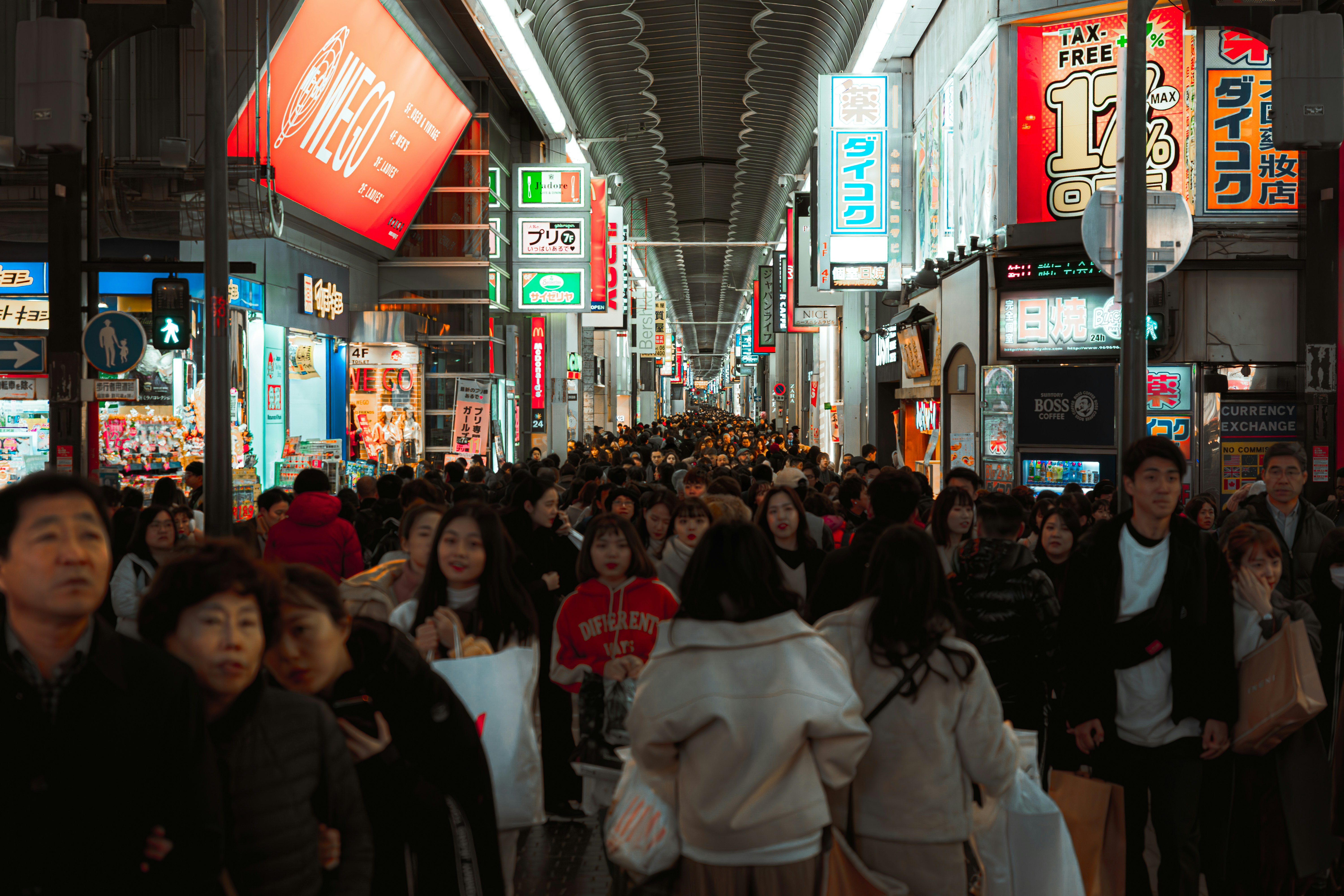 Crowded street market with many people and signs