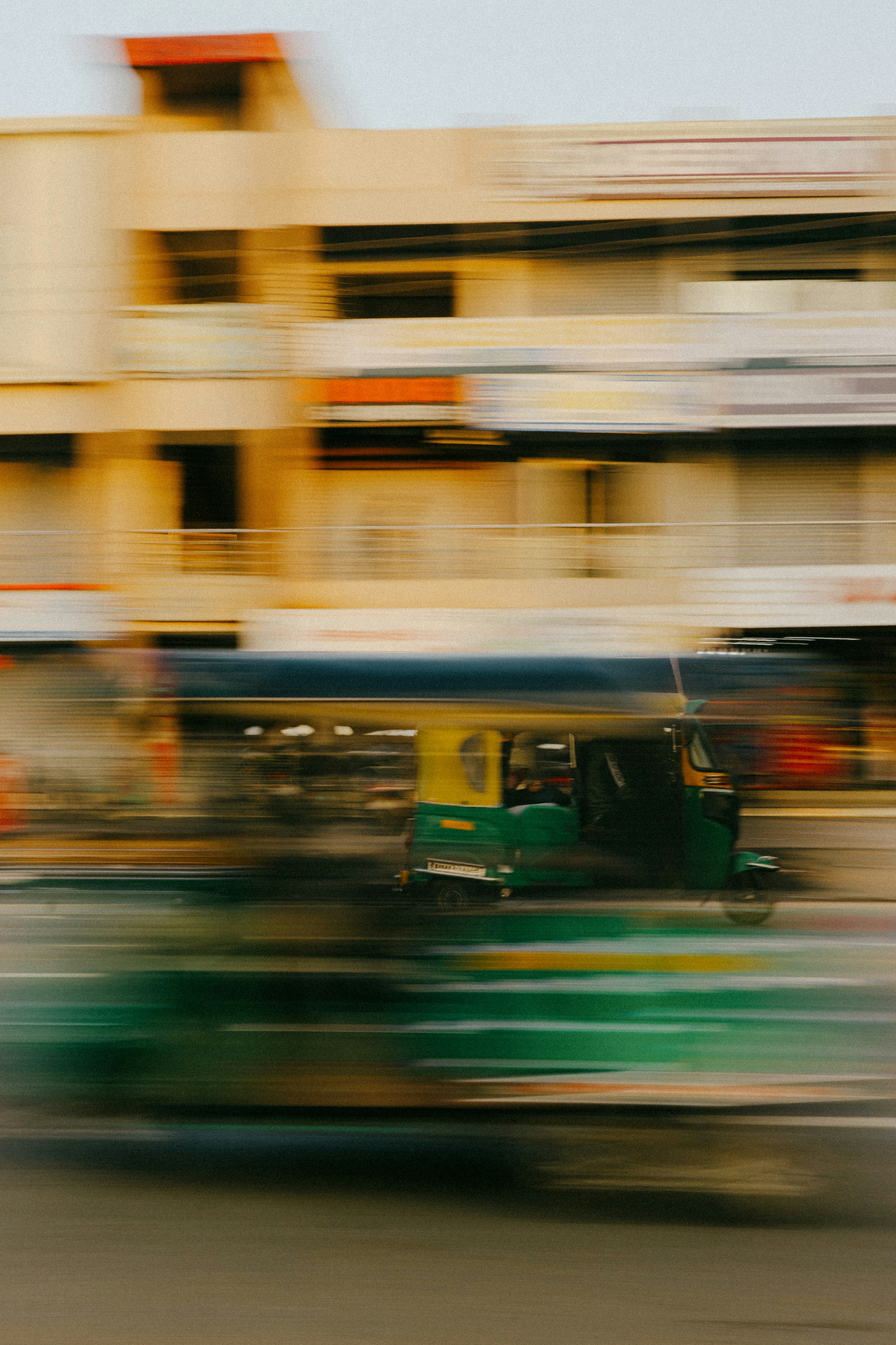 Auto rickshaw speeding through a blurred cityscape