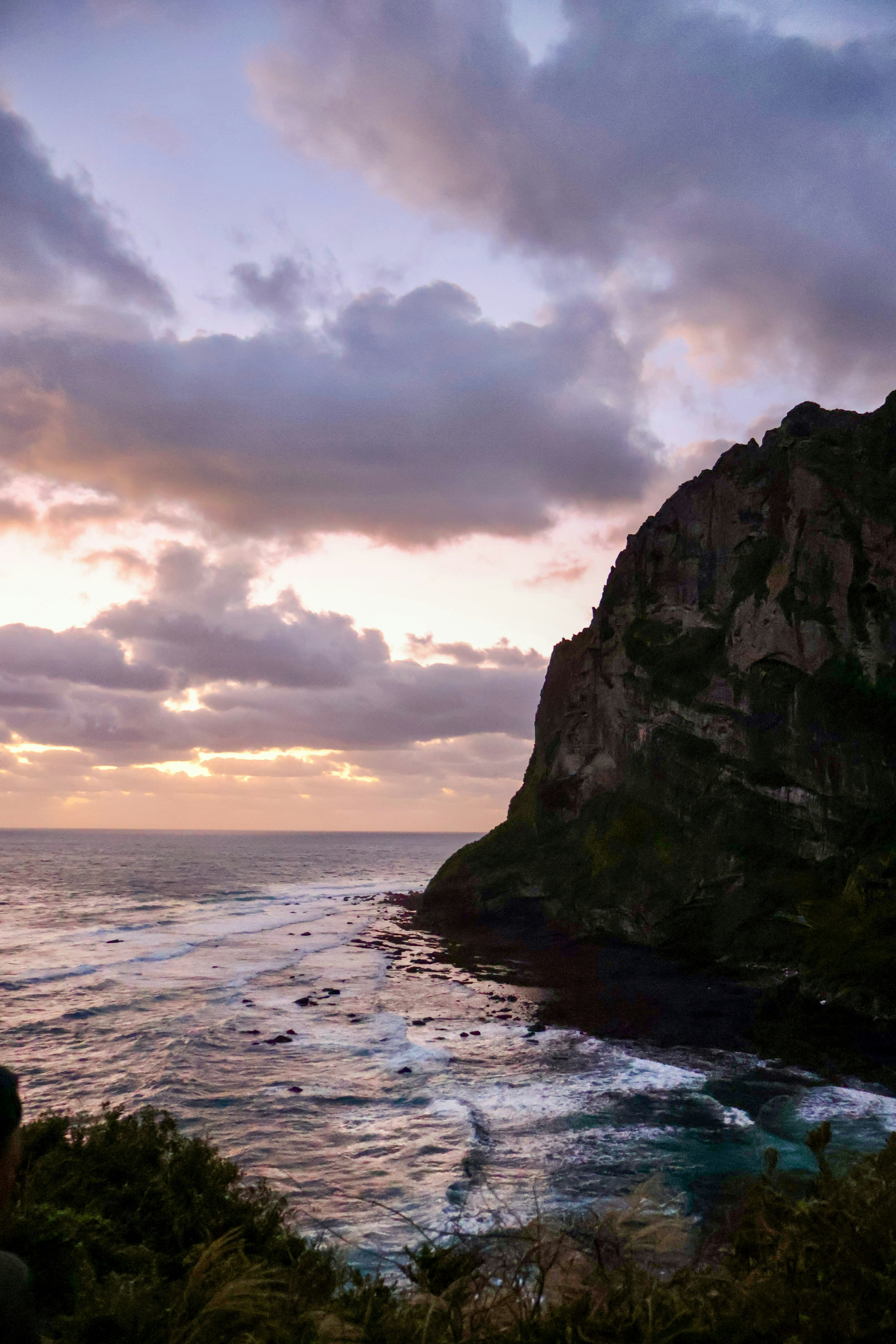 Dramatic cliff overlooking ocean at sunset