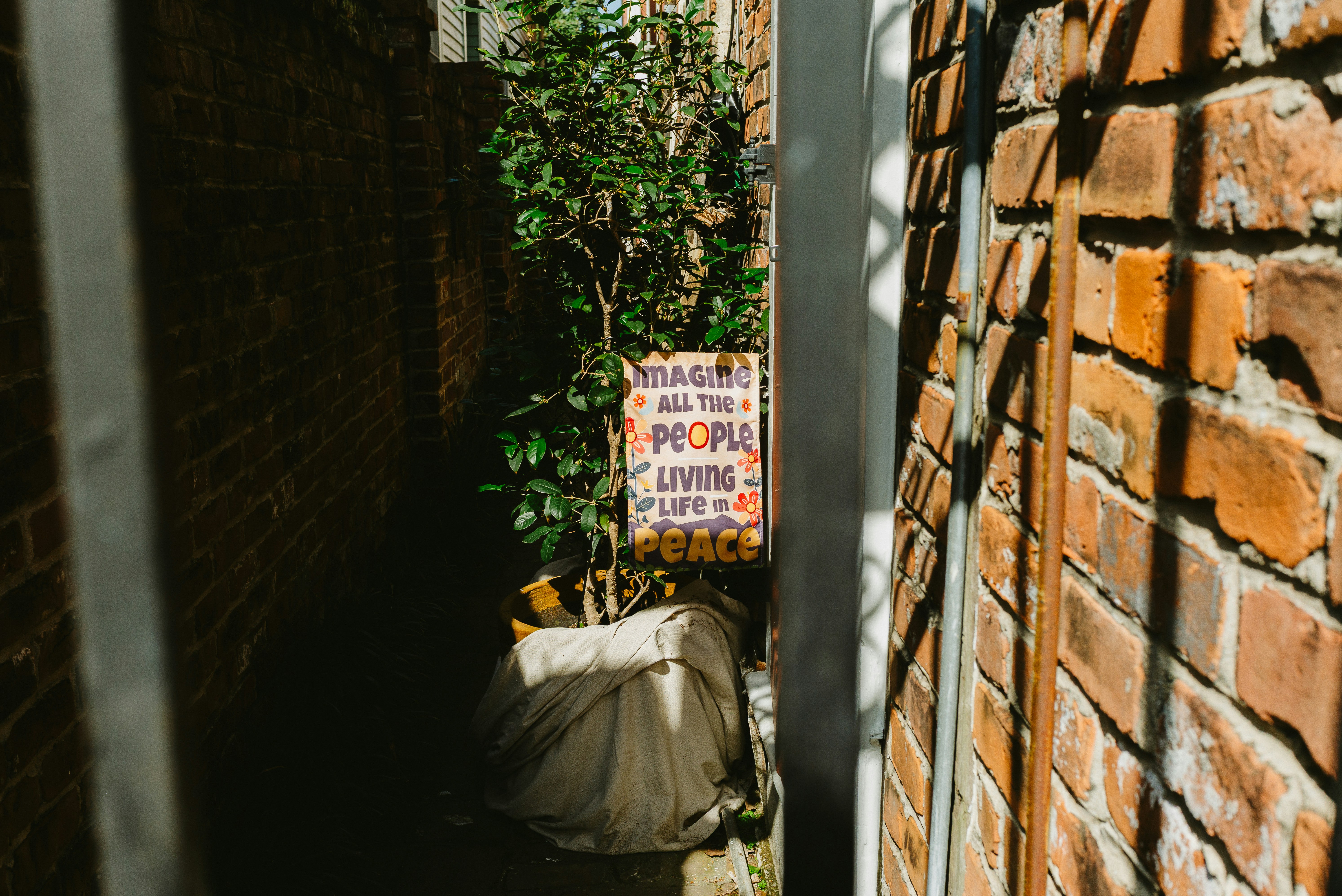 Un cartello con un testo in un vicolo stretto.