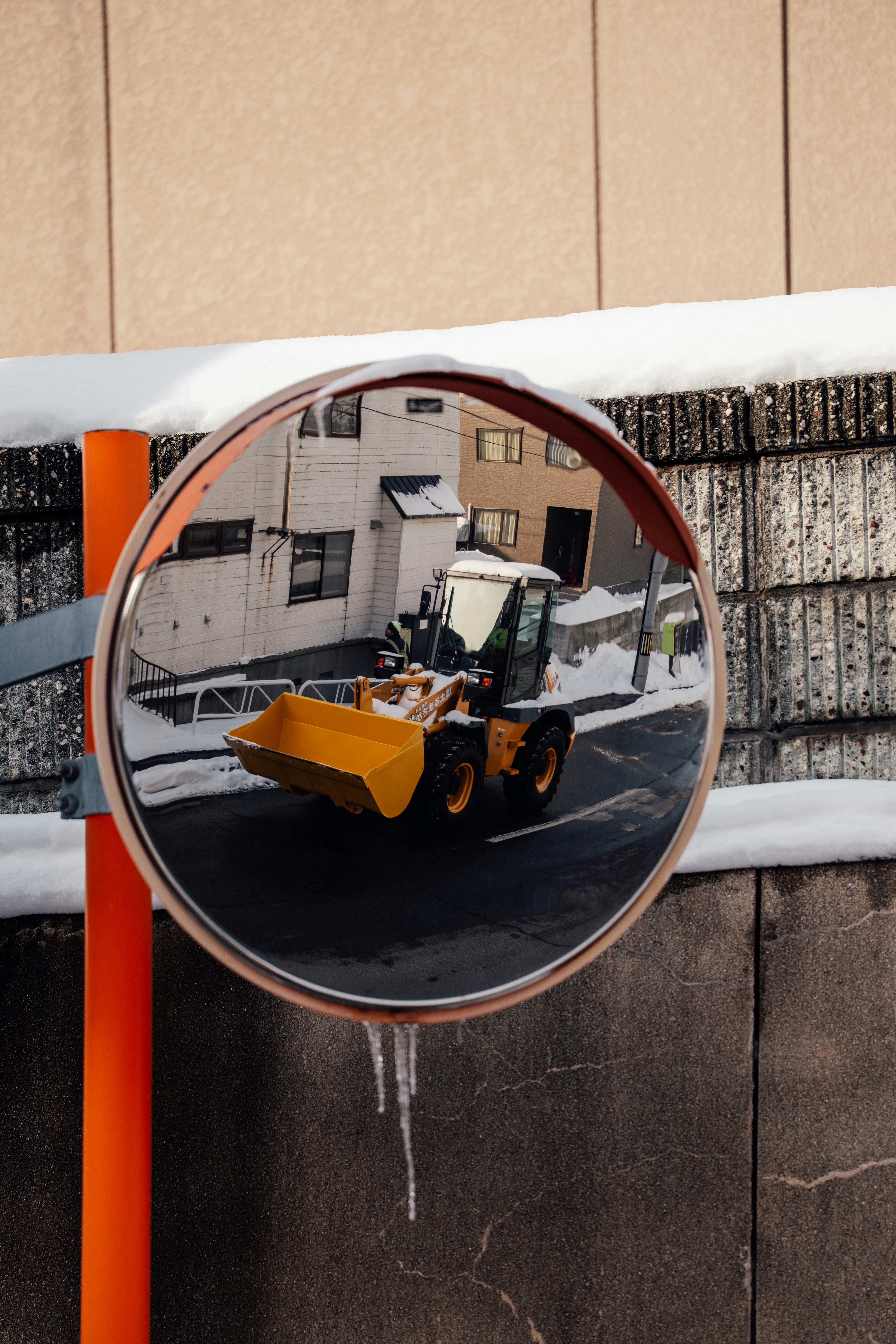 Gelber Bulldozer spiegelt sich in einem konvexen Spiegel