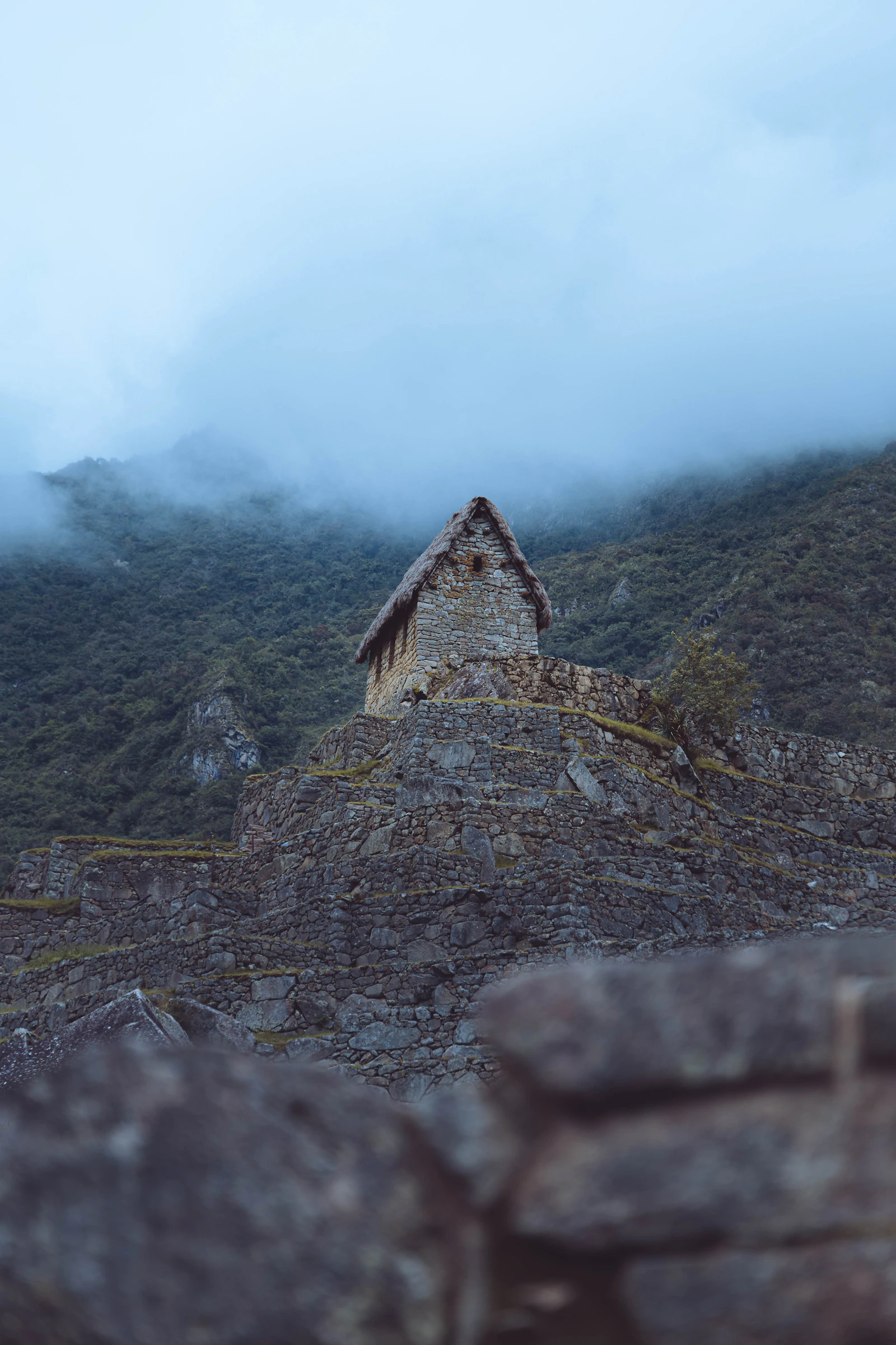 Ancient stone ruins with misty mountain peaks in Peru