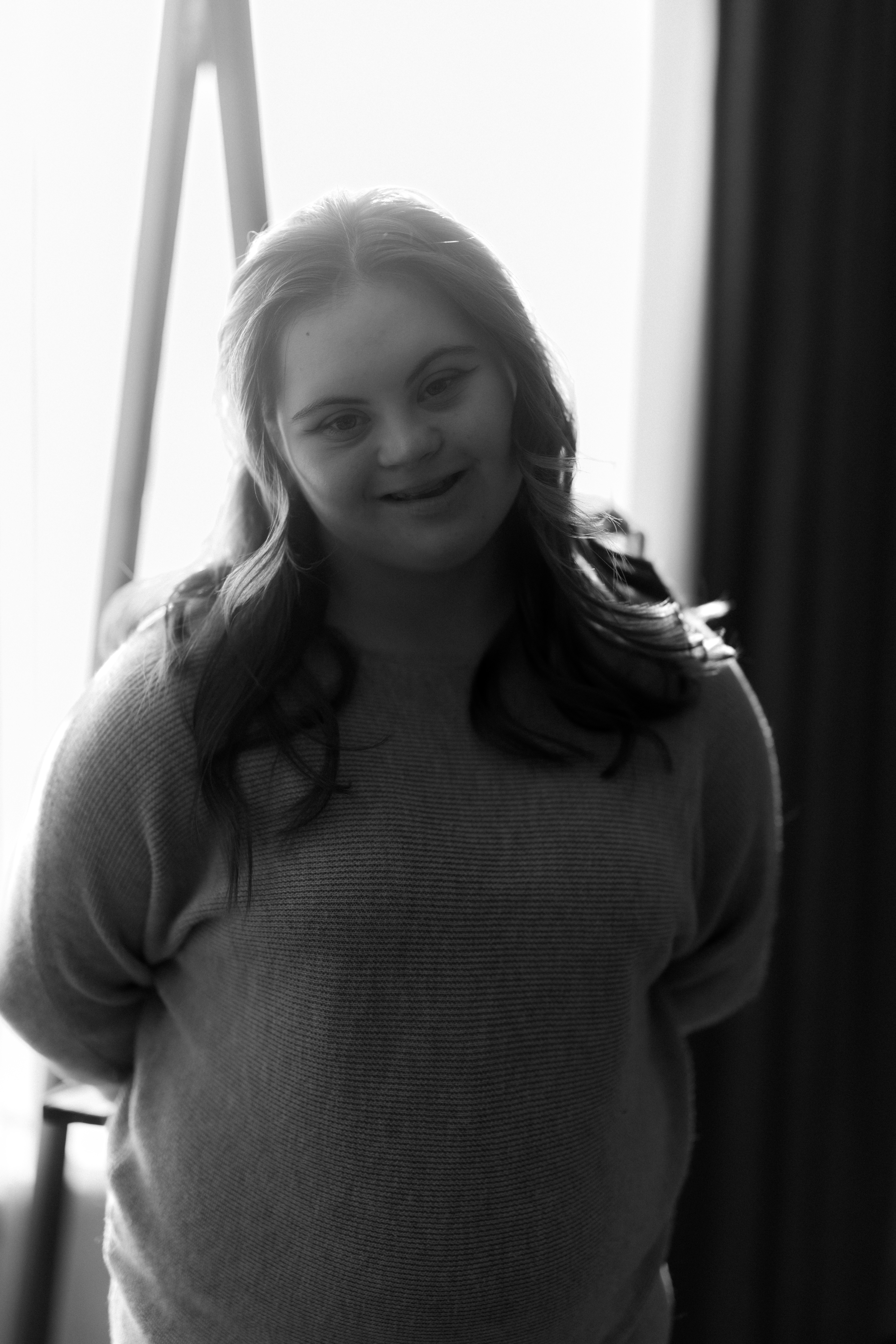 Eine junge Frau mit Down-Syndrom lächelt