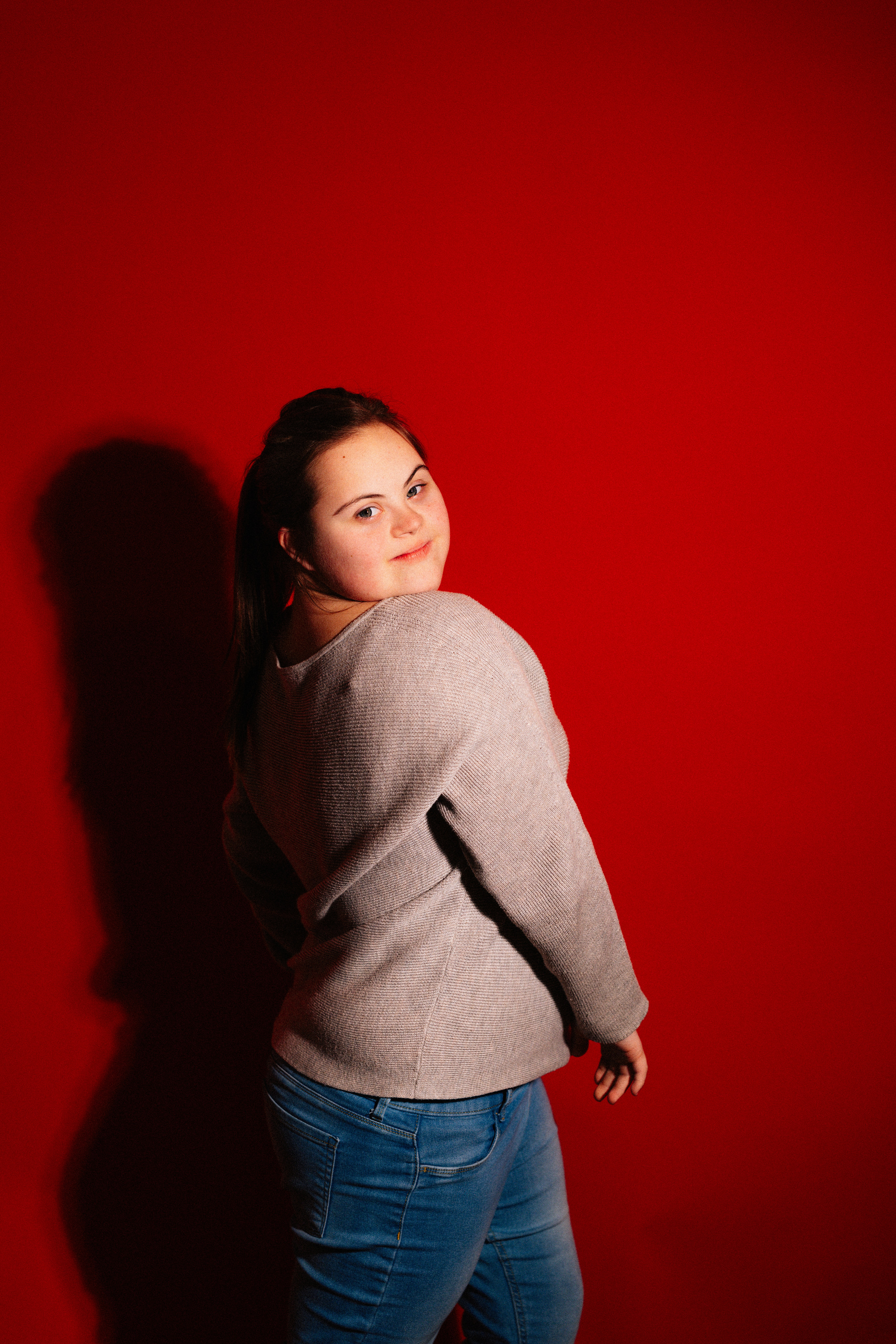 Young woman with down syndrome against red background