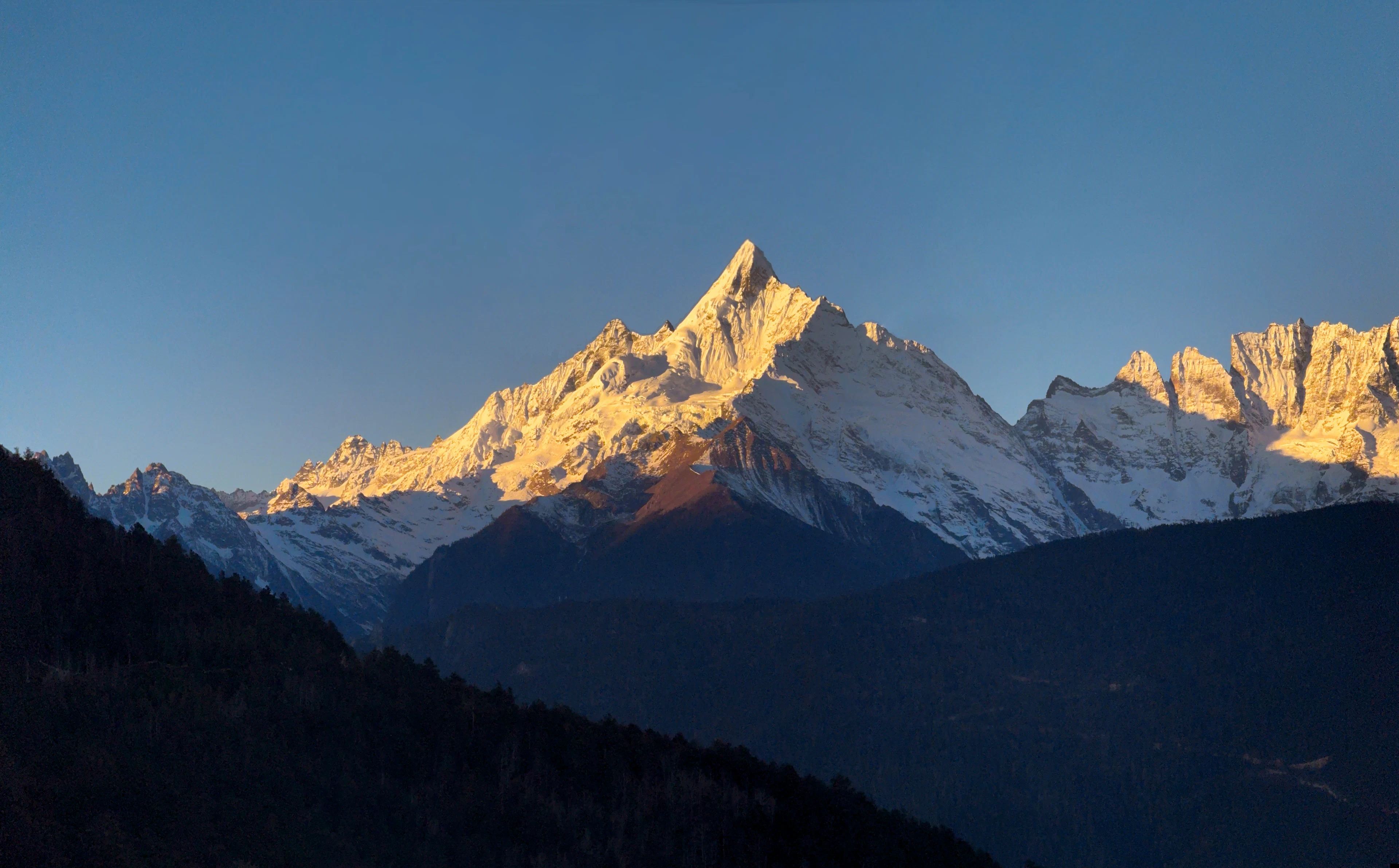 Snow-capped peaks bathed in golden sunrise light