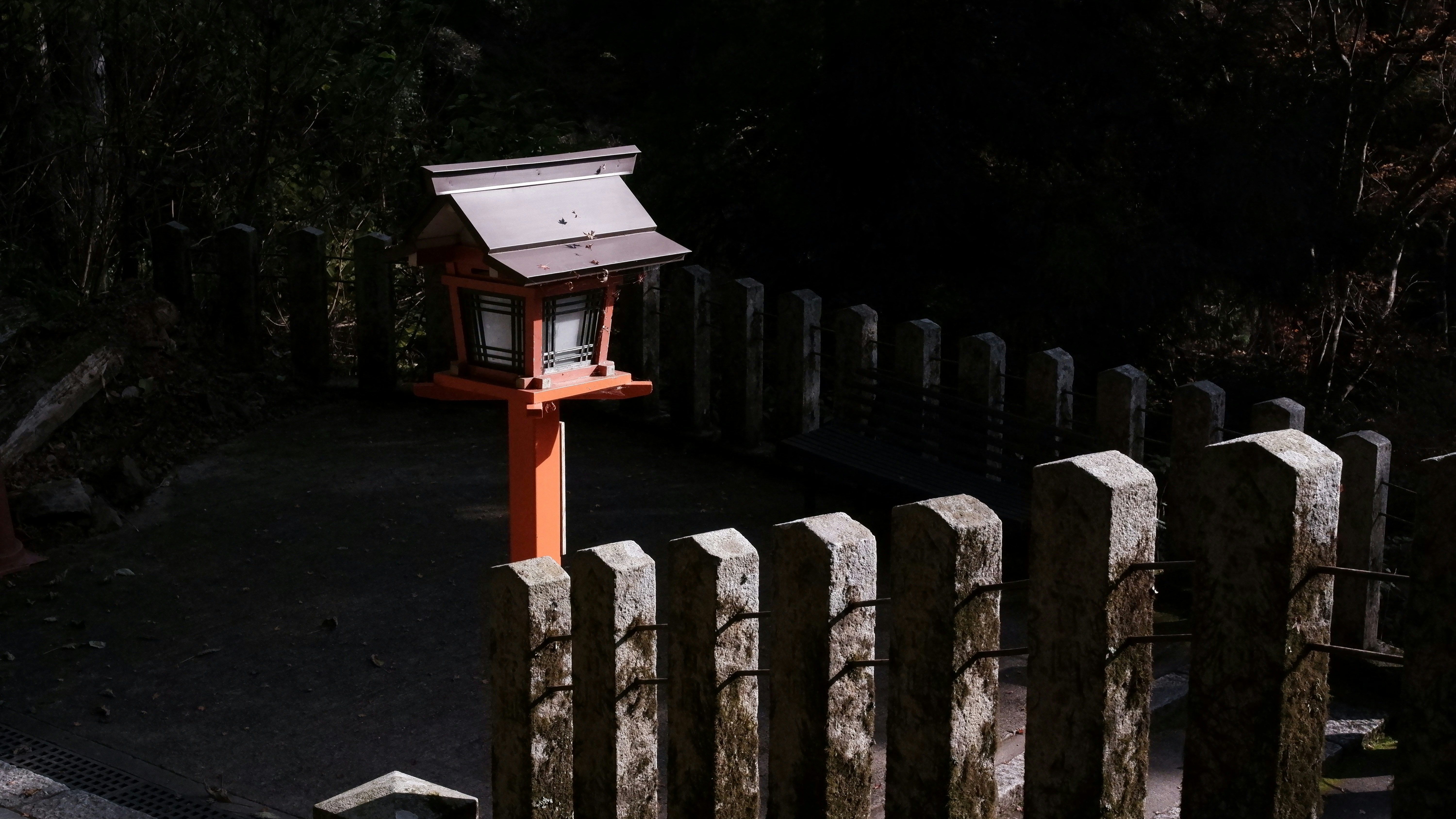 A small shrine lantern with a wooden fence