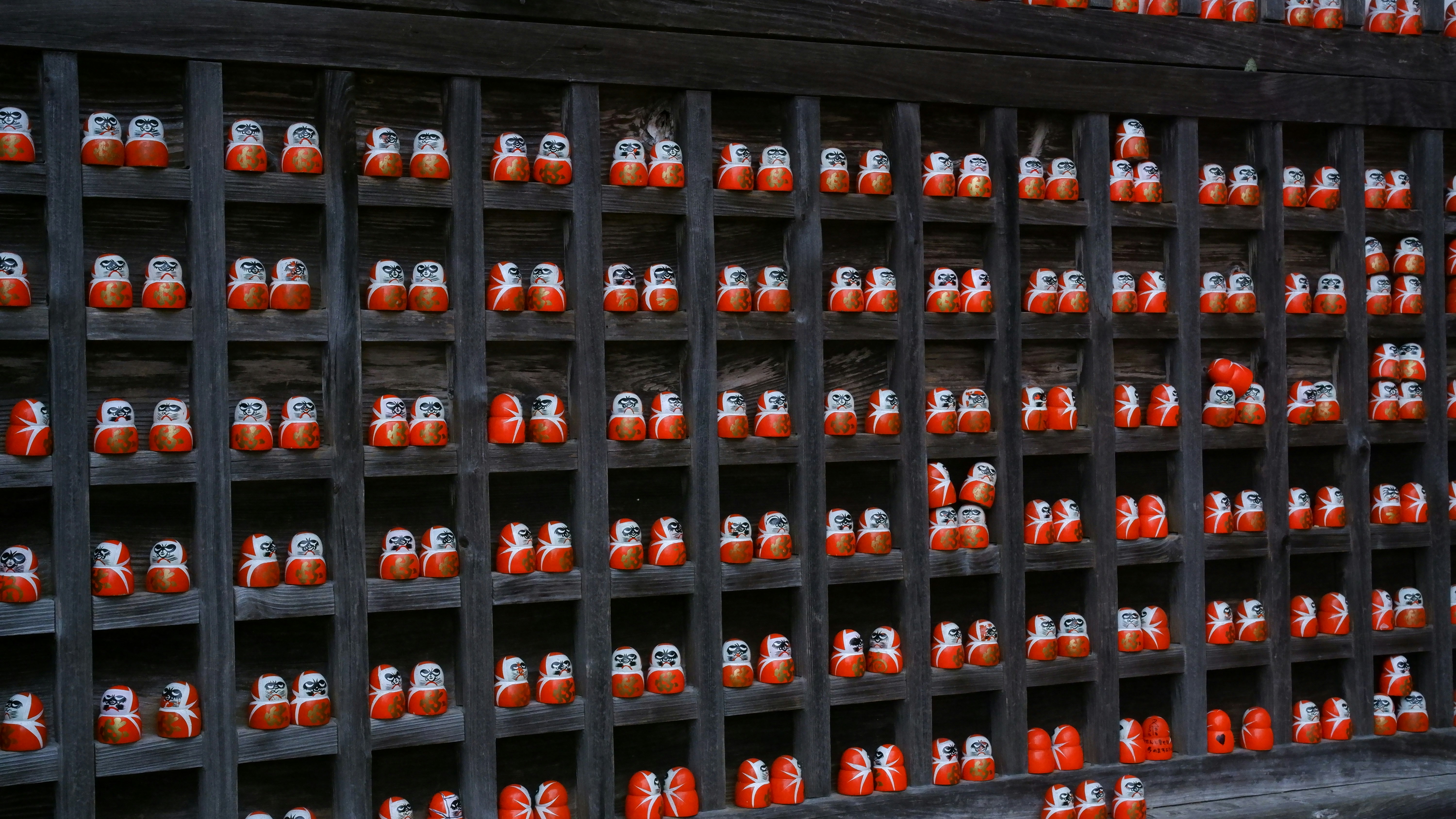 Rows of small wooden dolls in a grid