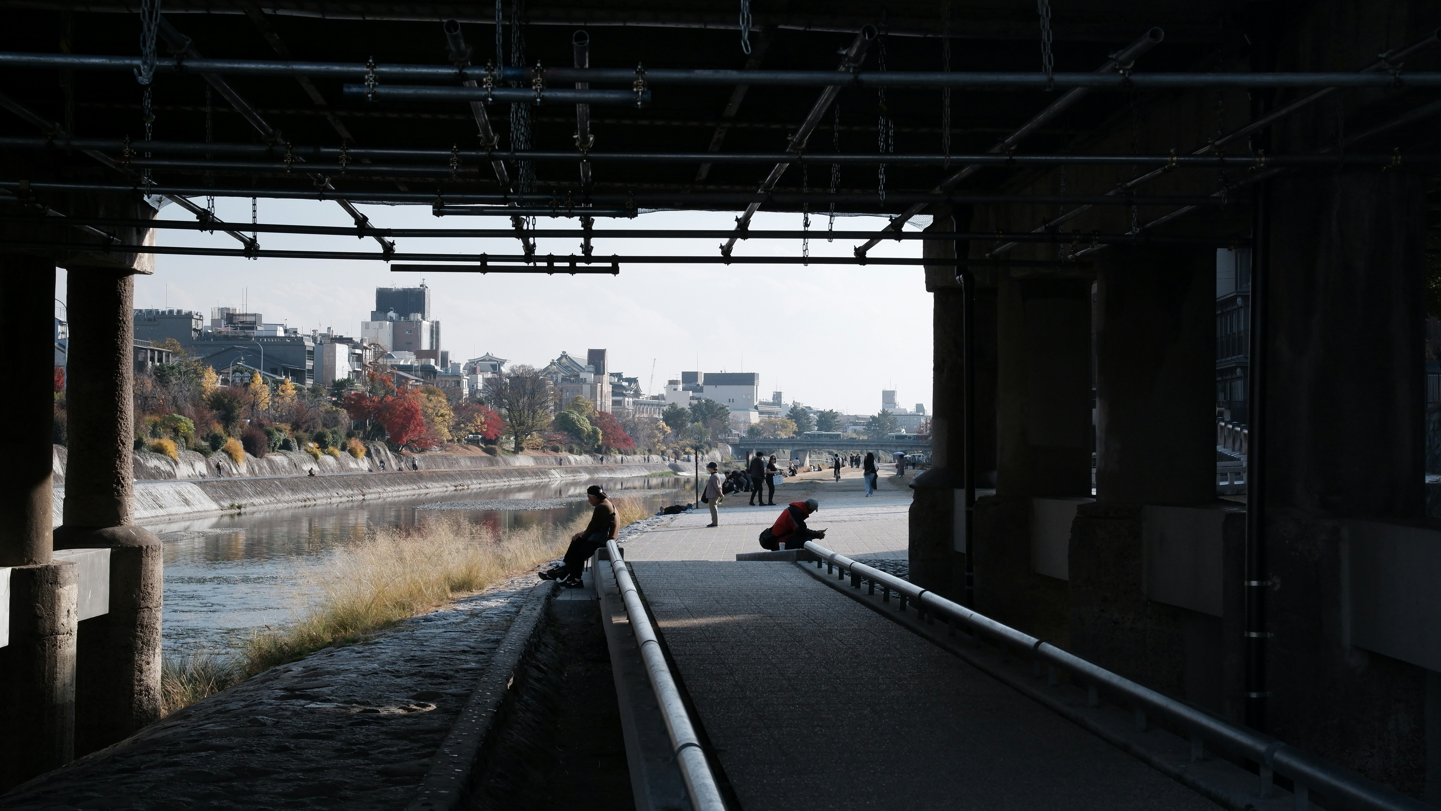 City skyline seen from under a bridge by a river