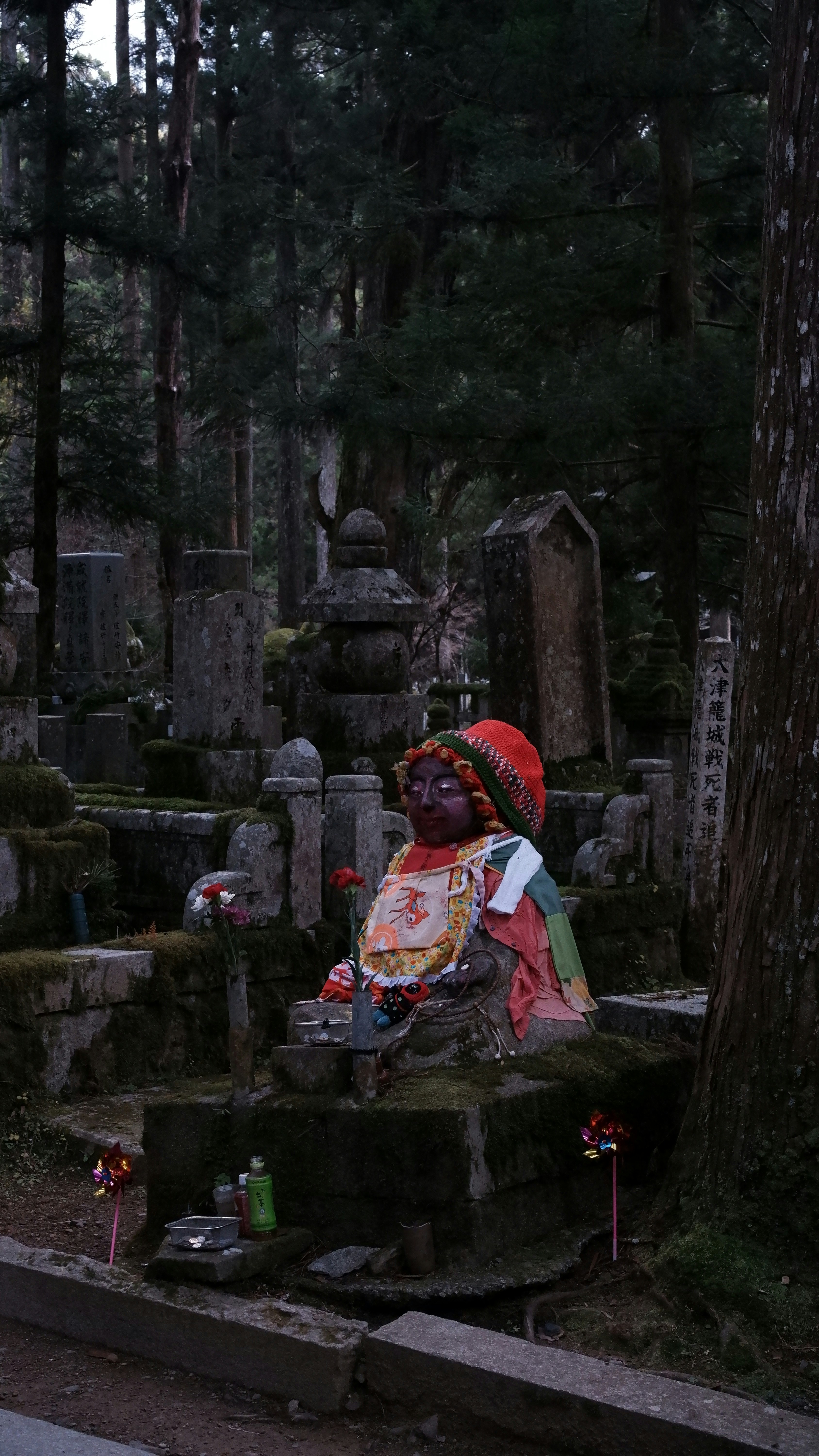 A statue of a child in a cemetery with trees