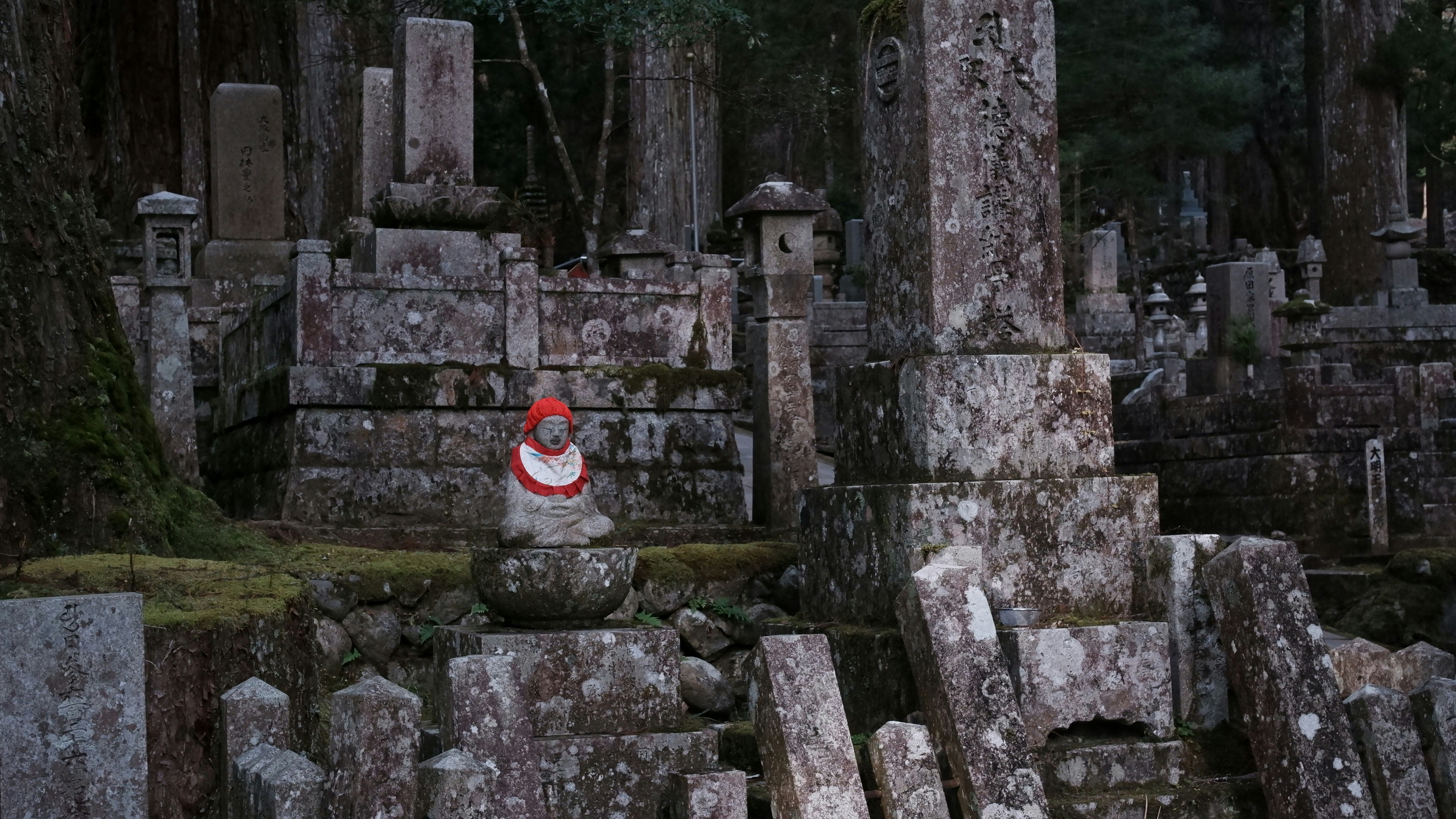 Ancient stone graveyard with a small statue.