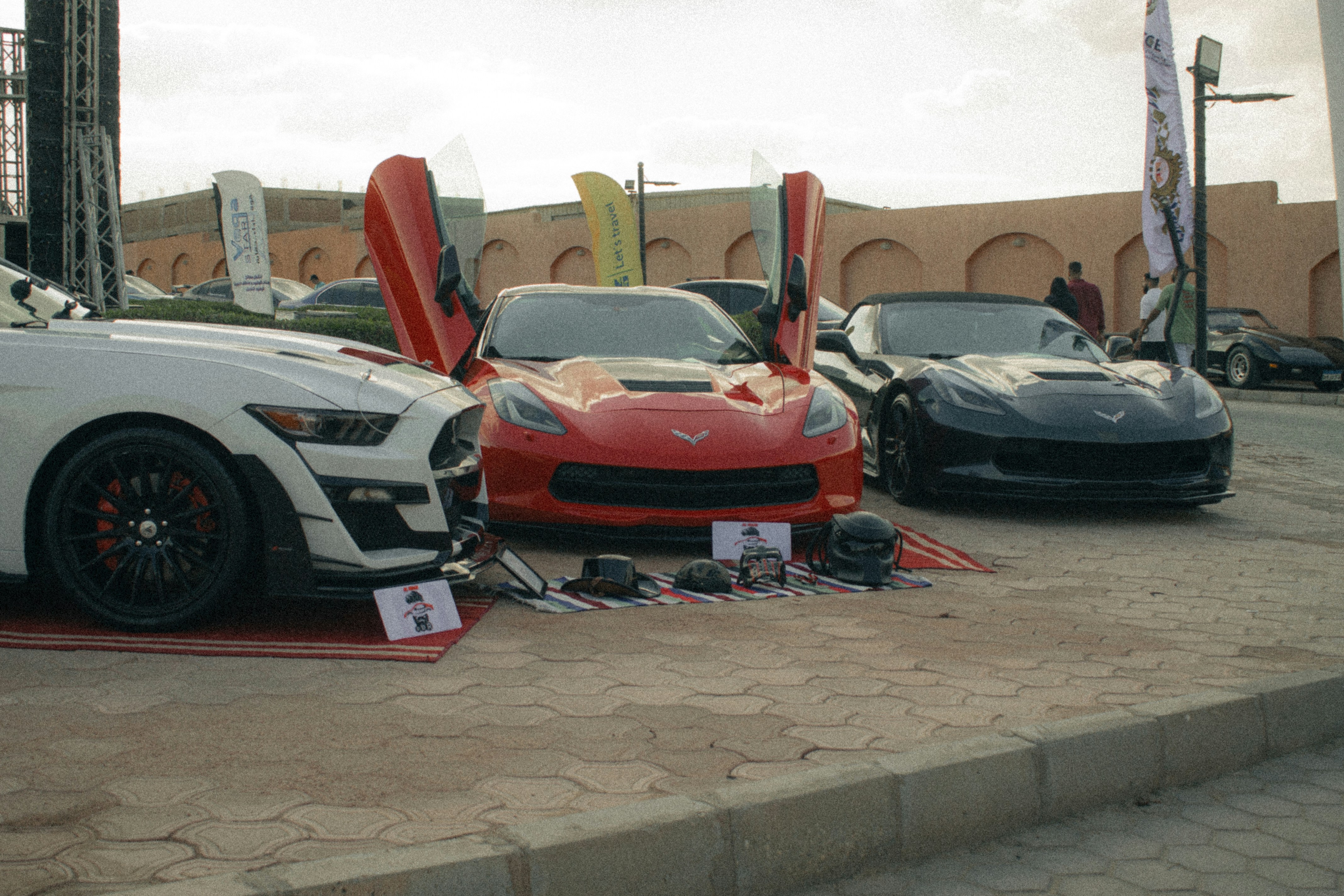 Three sports cars with doors open on display