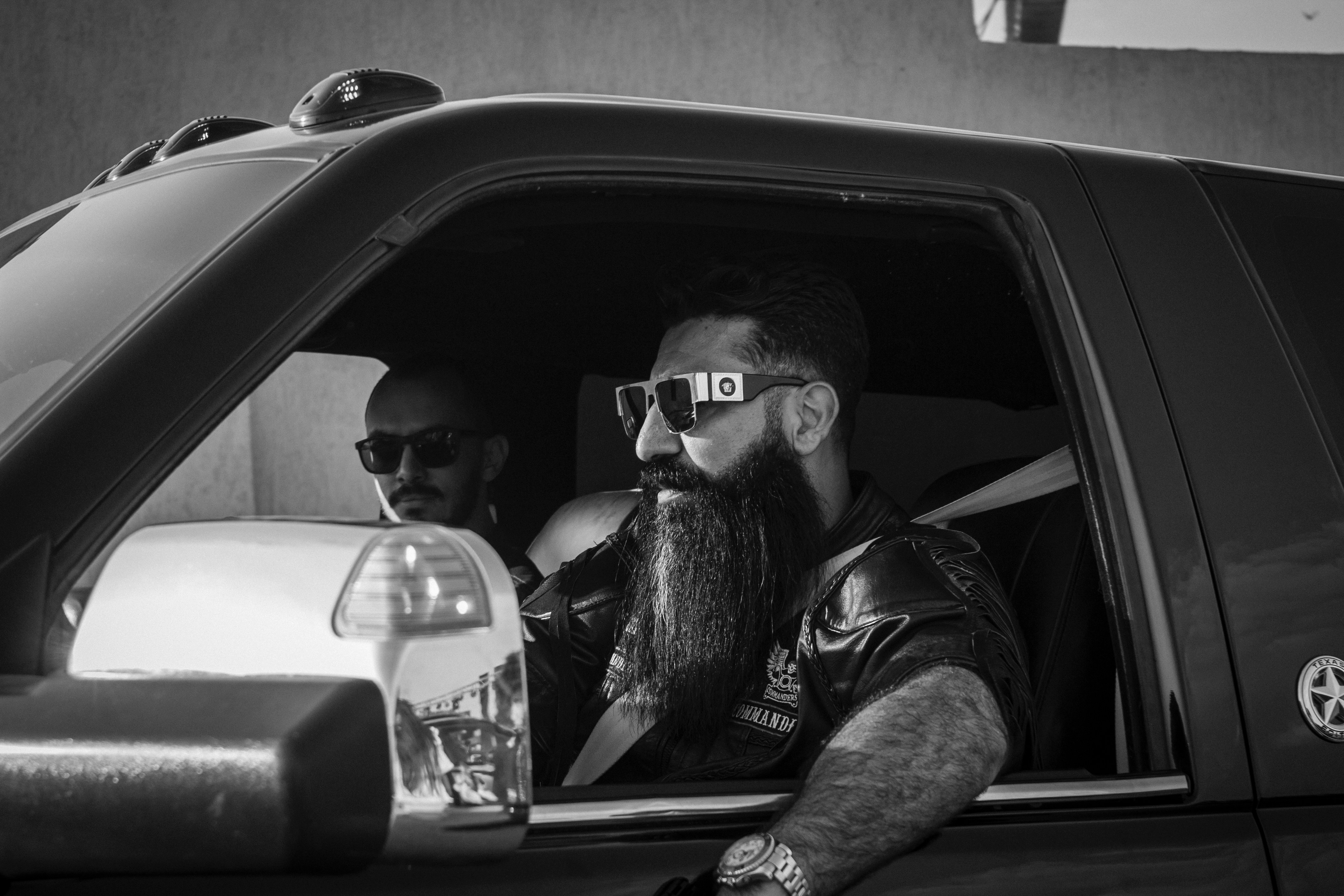 Two men in sunglasses inside a vehicle