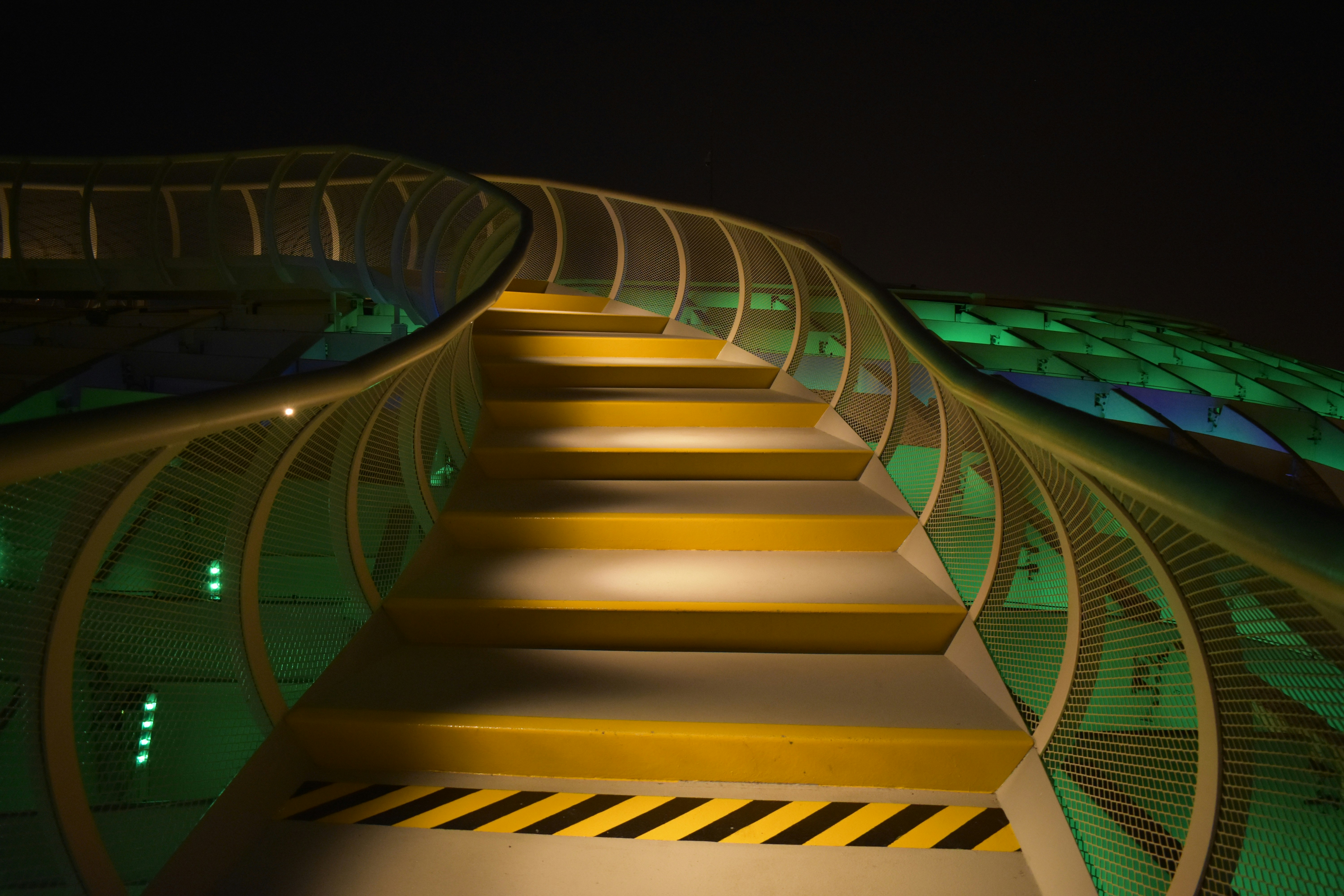 Scala moderna illuminata con gradini gialli di notte