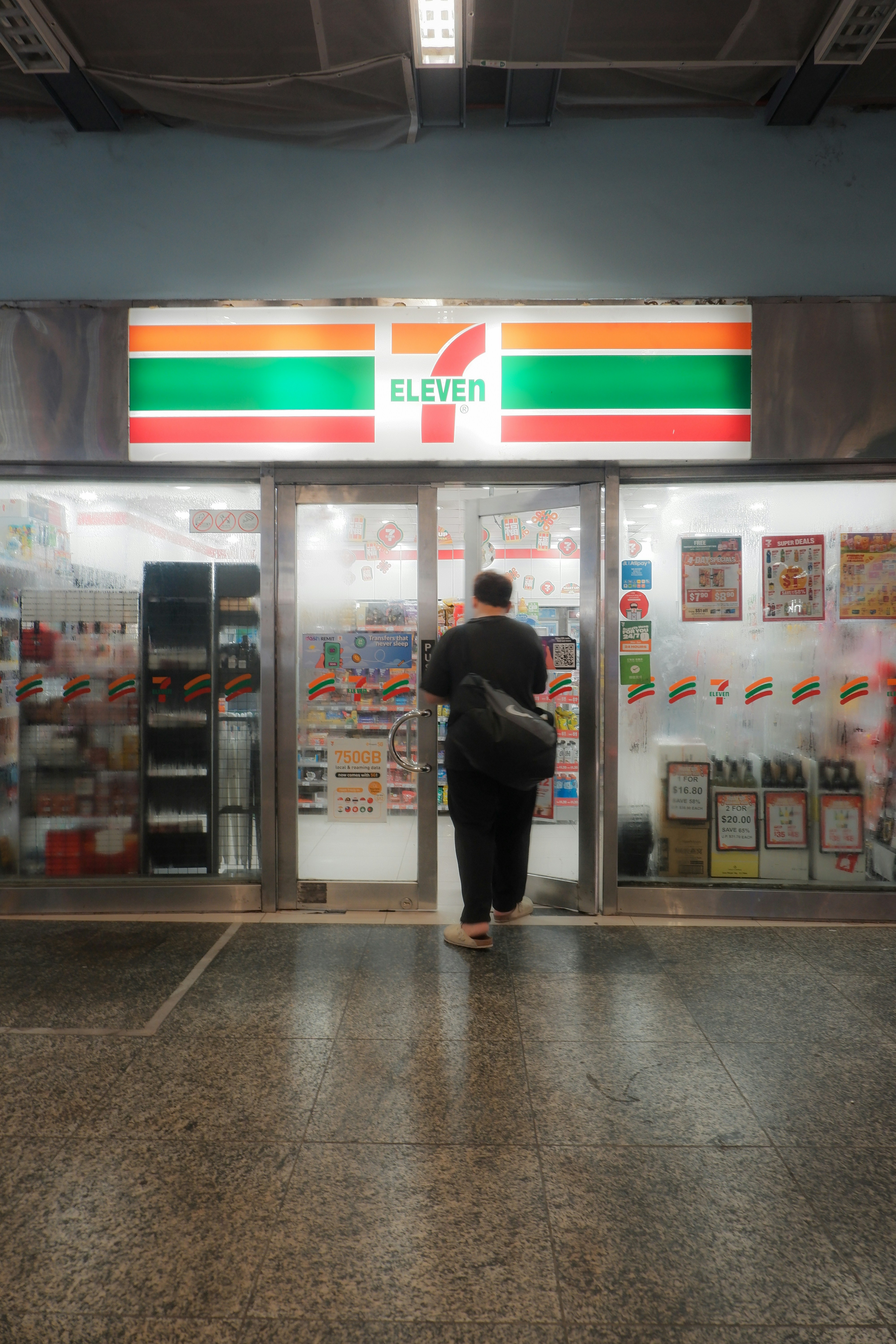 Person entering a 7-eleven convenience store.