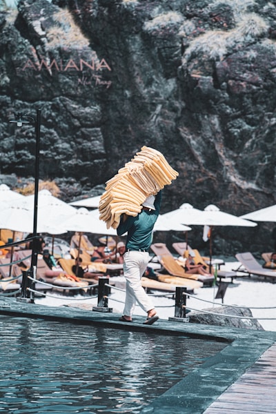 Man carrying towels on a sunny beach resort