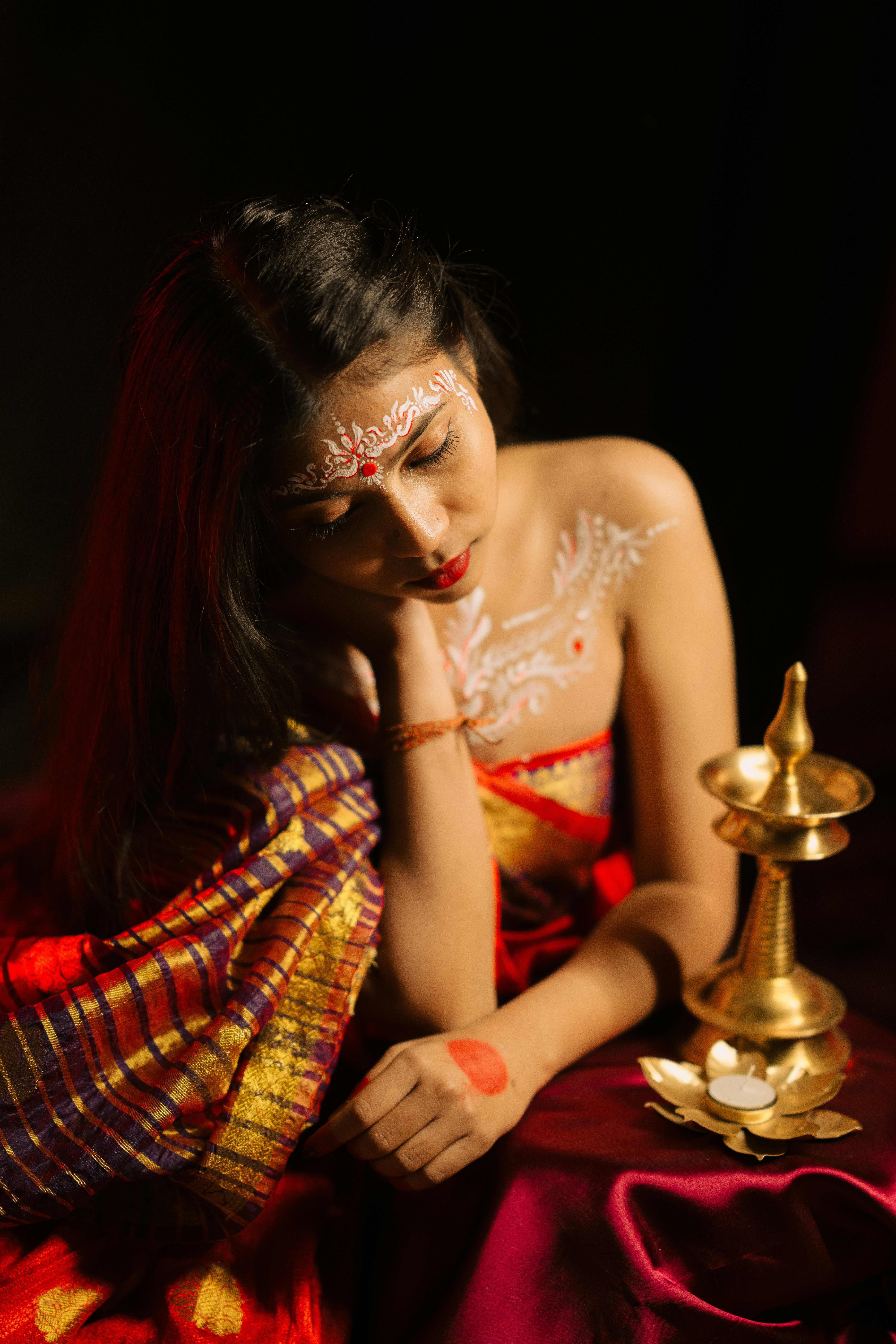Woman with traditional markings and a lamp