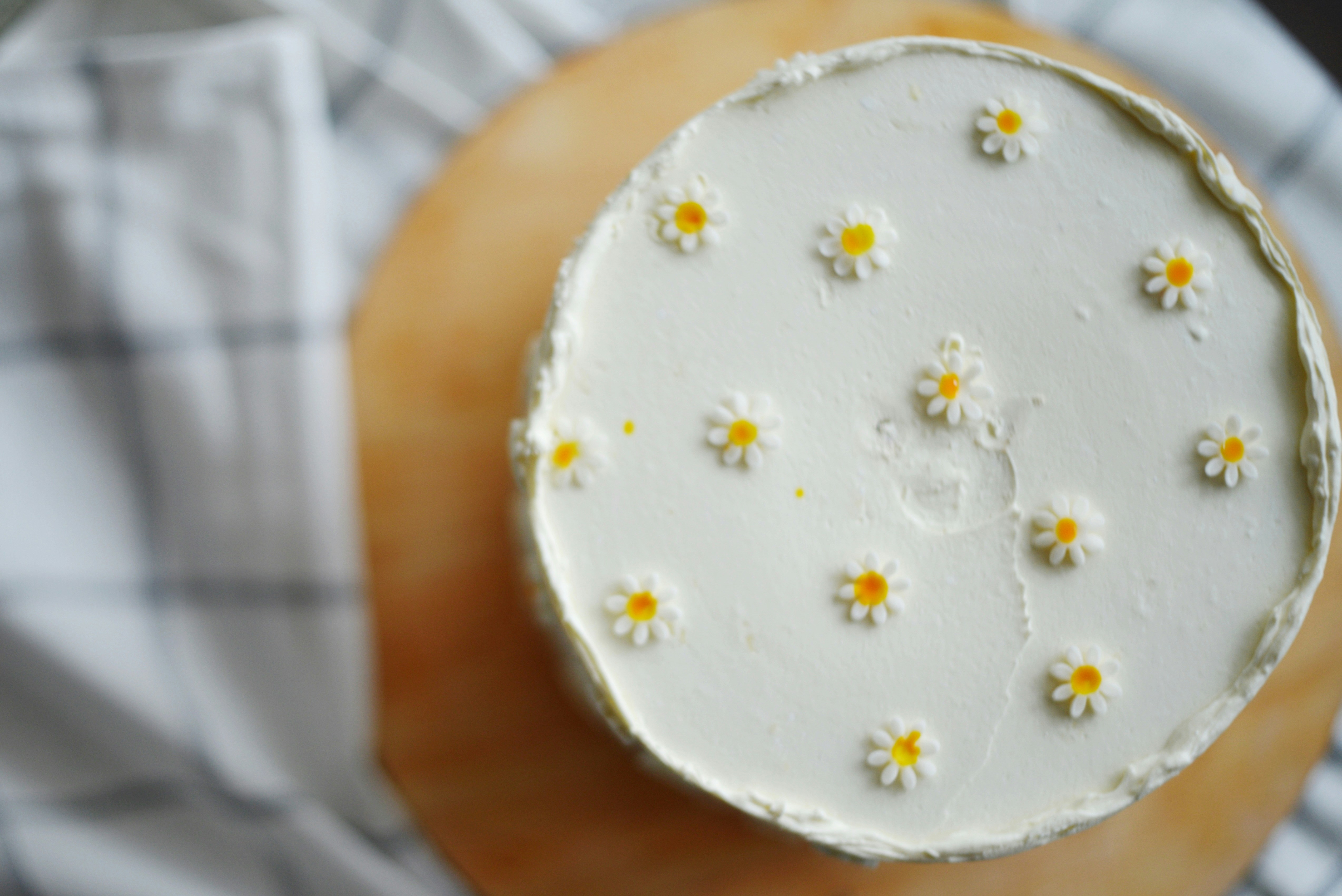 Pastel blanco decorado con pequeñas flores de margarita