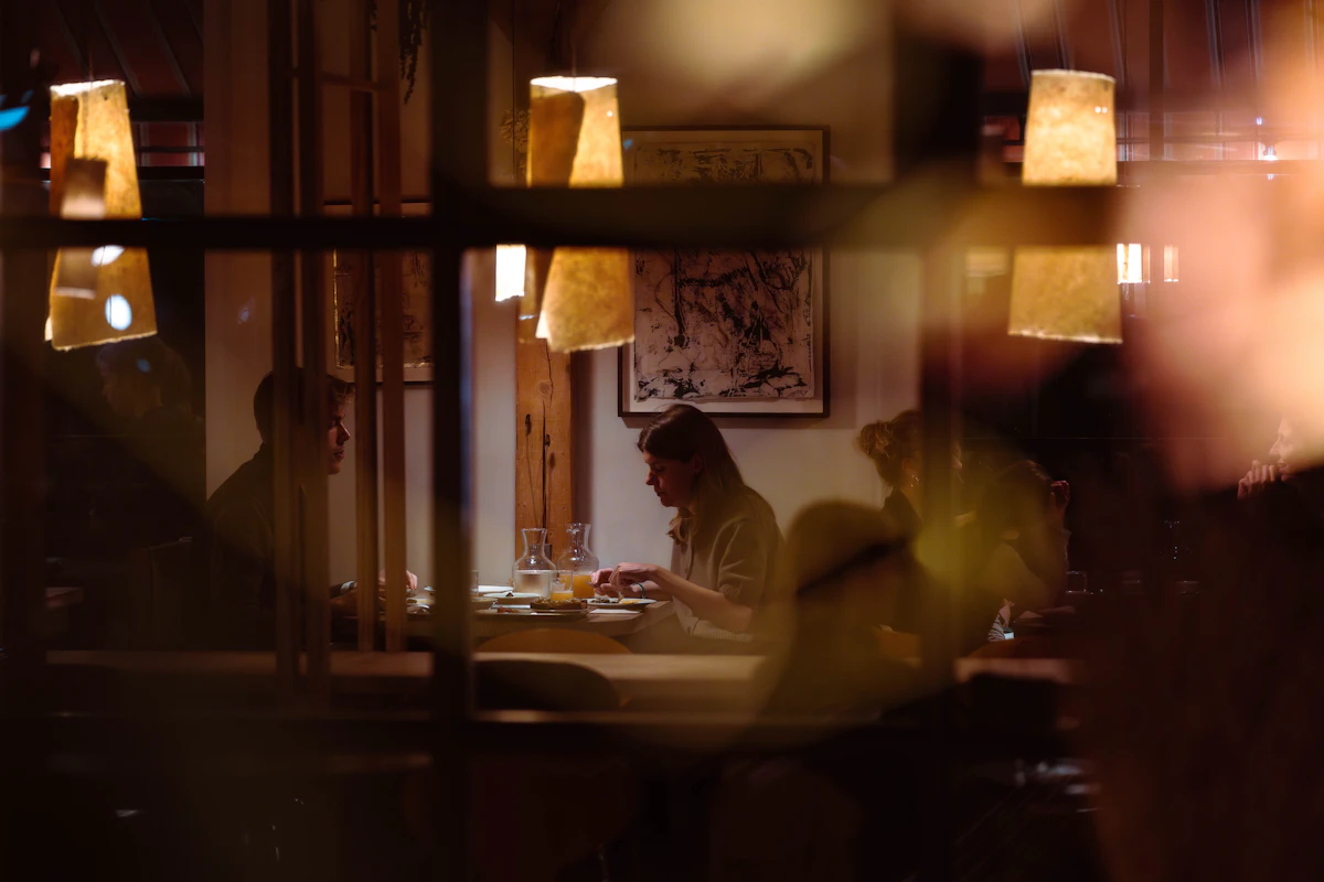 People dining at tables in a dimly lit restaurant