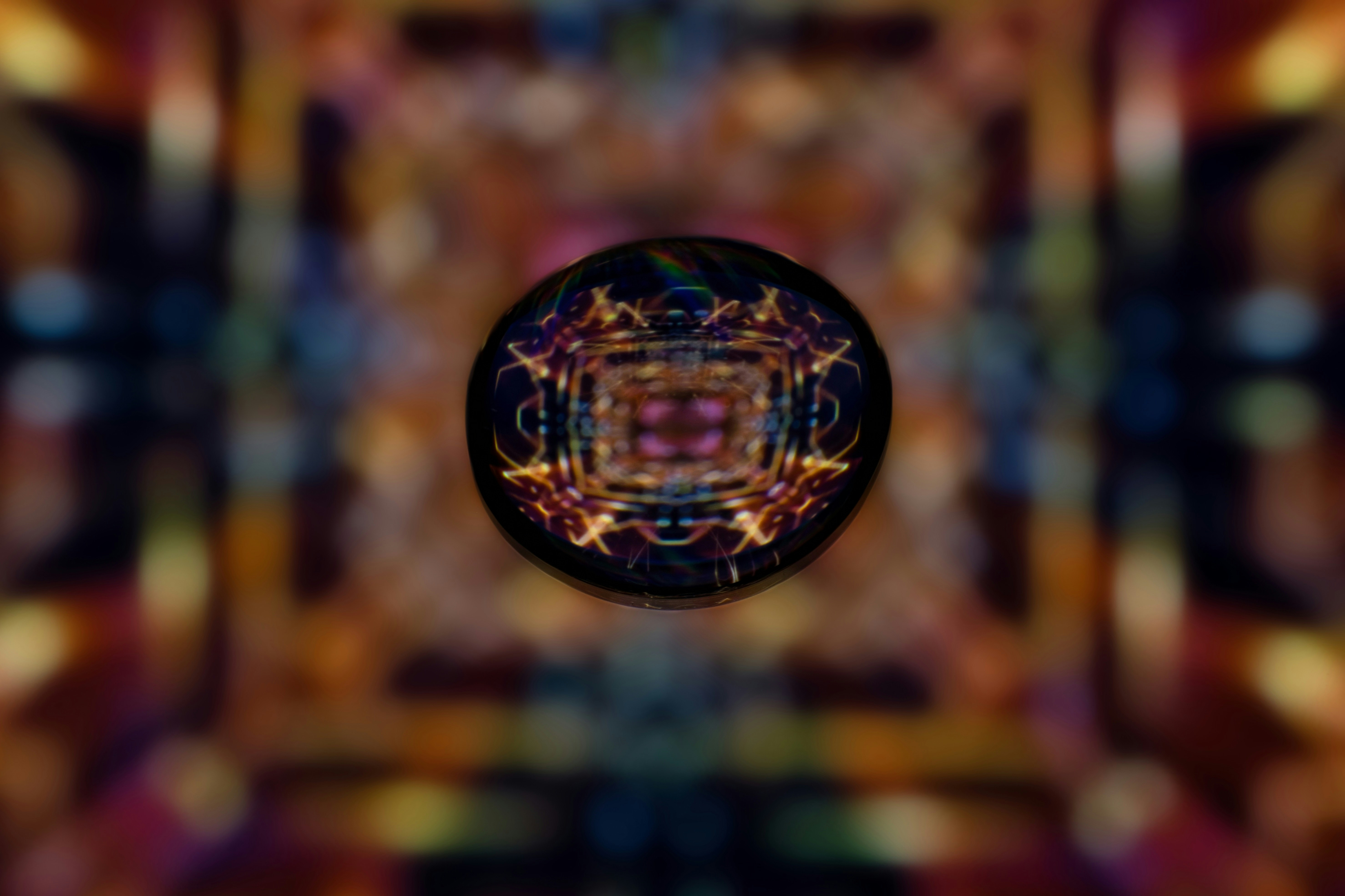 抽象的な円形パターンにカラフルなぼやけた背景が描かれています