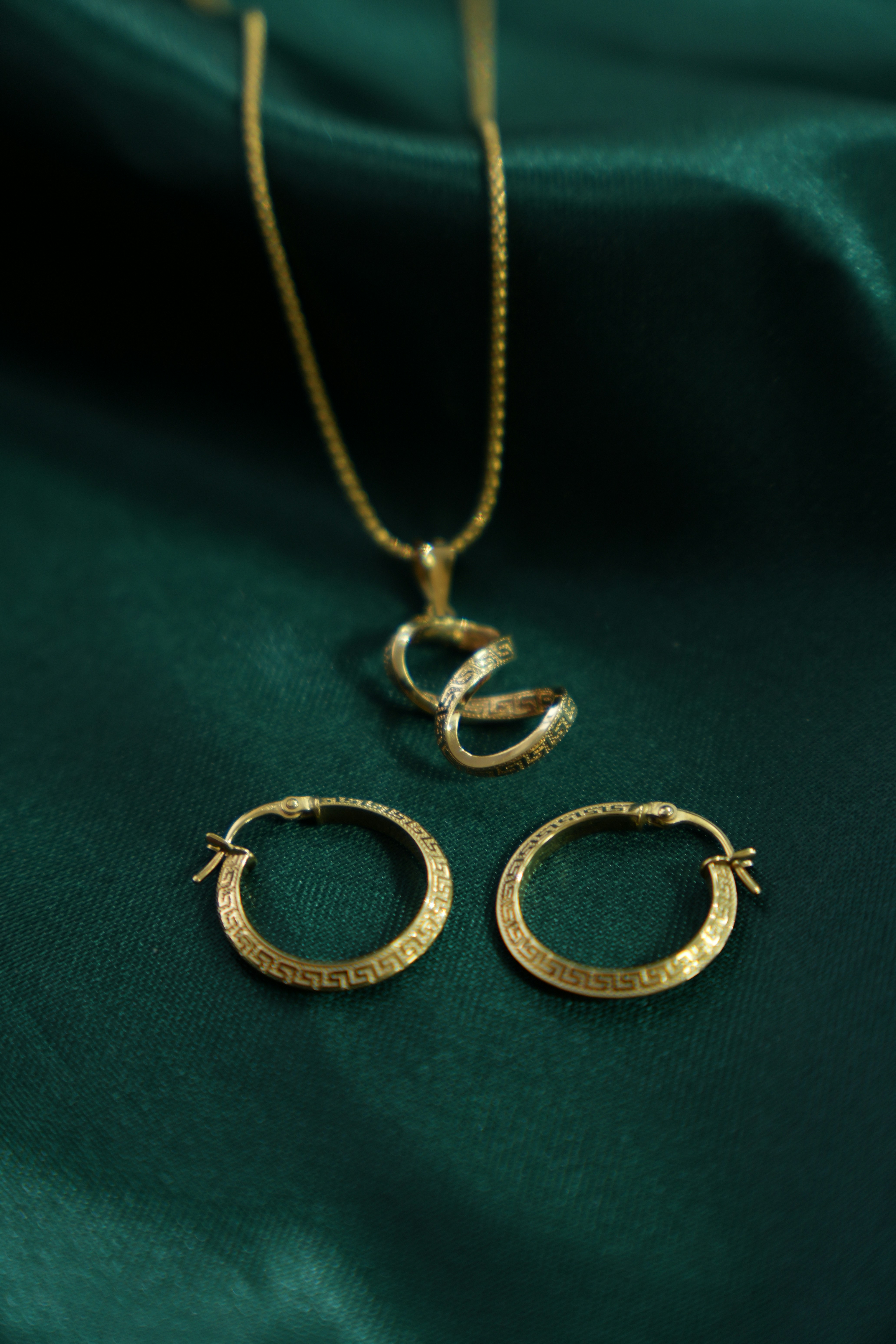 Gold snake pendant necklace and hoop earrings