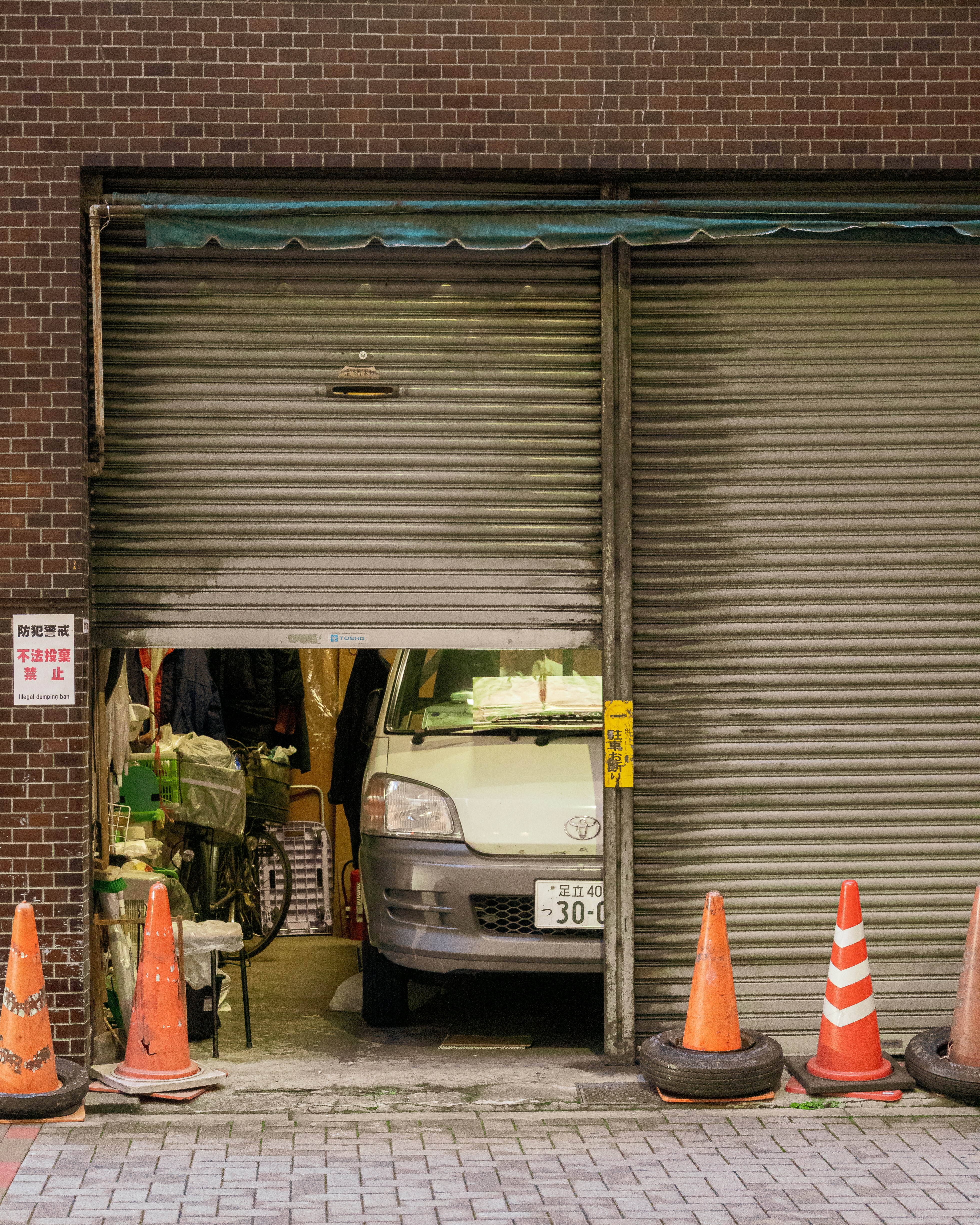 A van parked inside a garage with open shutters.