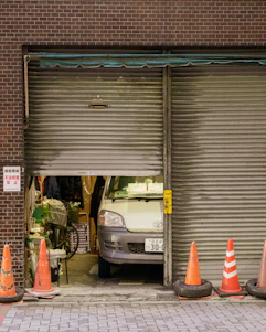 A van parked inside a garage with open shutters.