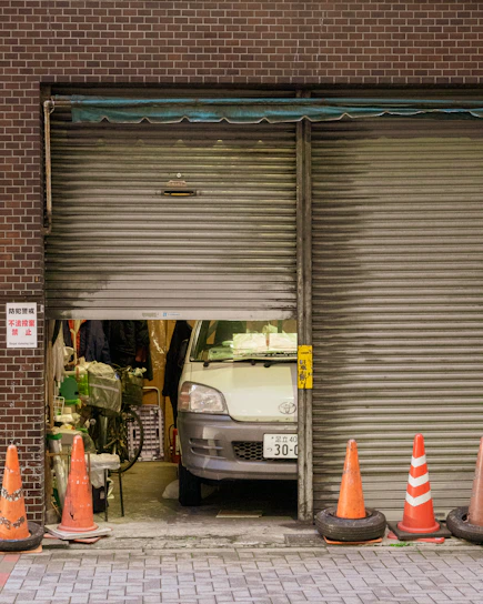 A van parked inside a garage with open shutters.