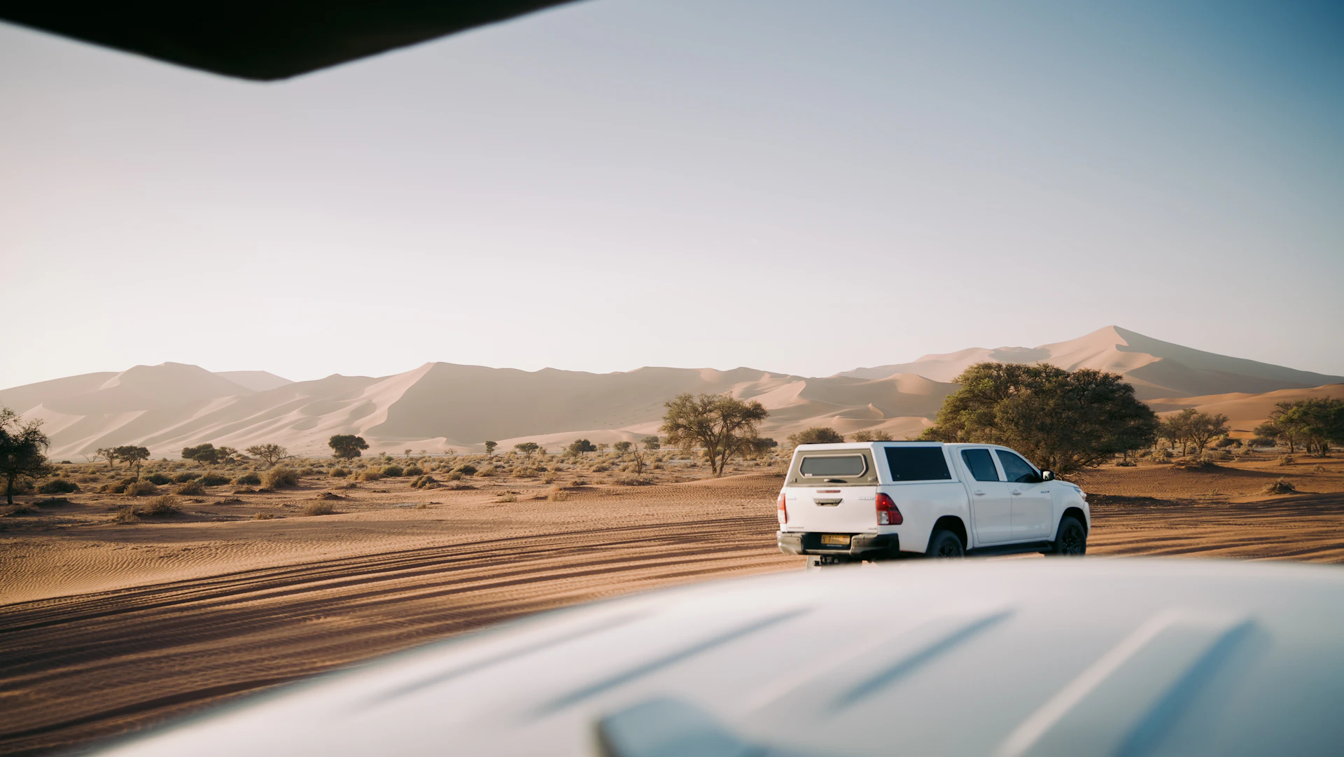 White suv driving through a desert landscape